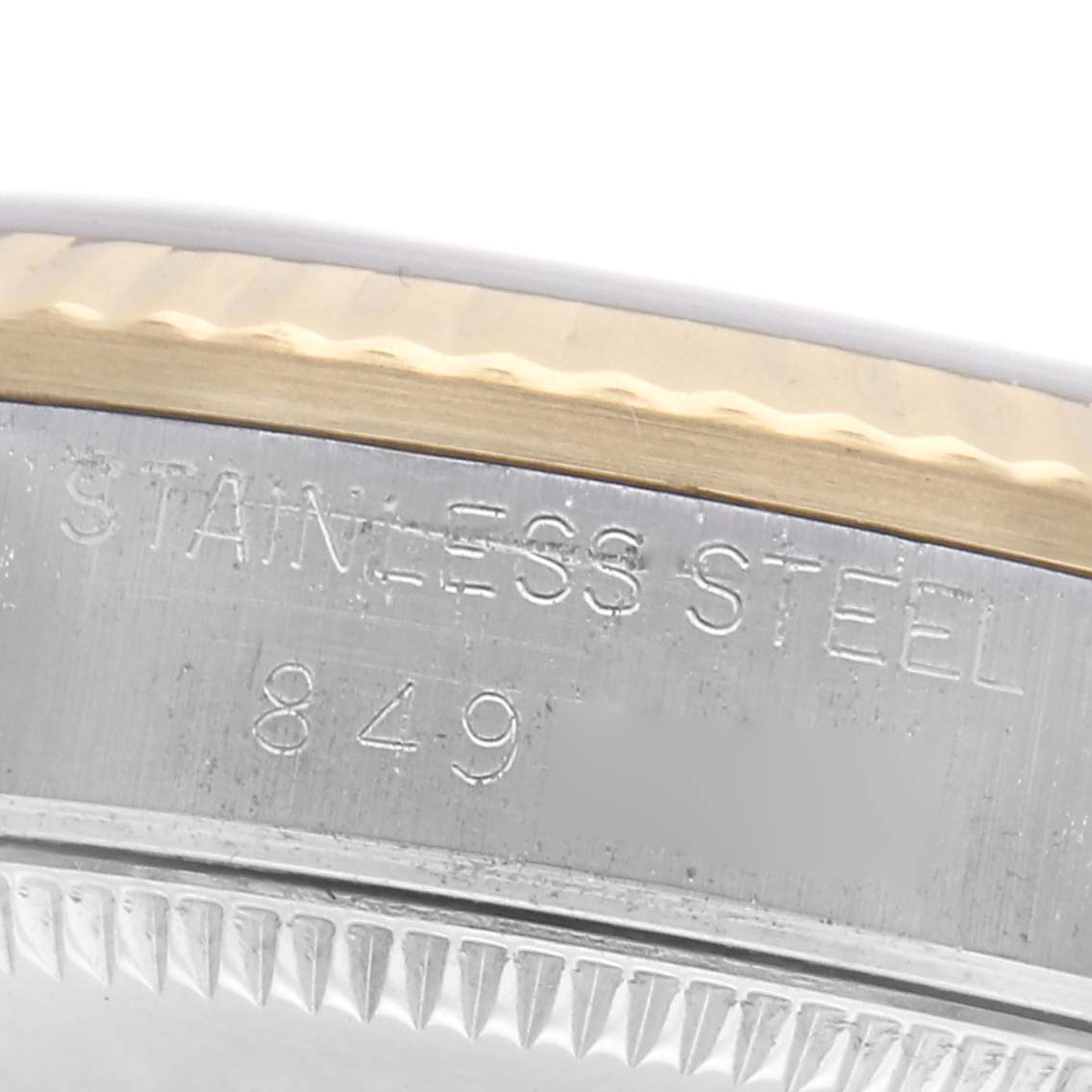 The image shows a close-up angle of the case side and bezel of a Rolex Mid-Size 68273 Women
s Steel and Gold (two tone) Black Dial 68273 Women
s Steel and Gold (two tone) Black Dial watch, highlighting the "Stainless Steel" engraving.