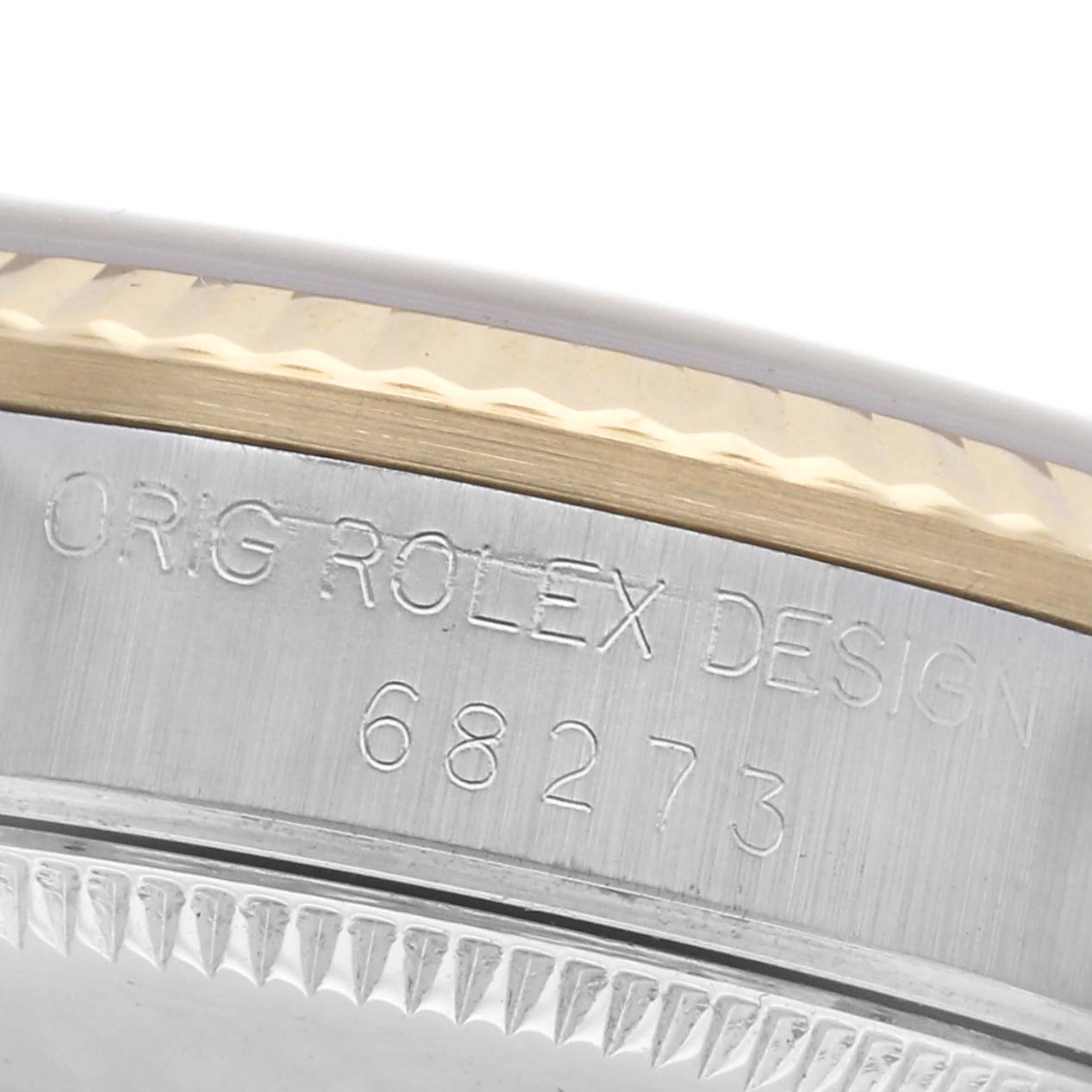 The image shows a close-up of the side of a Rolex Mid-Size 68273 Women
s Steel and Gold (two tone) Black Dial 68273 Women
s Steel and Gold (two tone) Black Dial watch, highlighting the engraved model number and bezel edge.