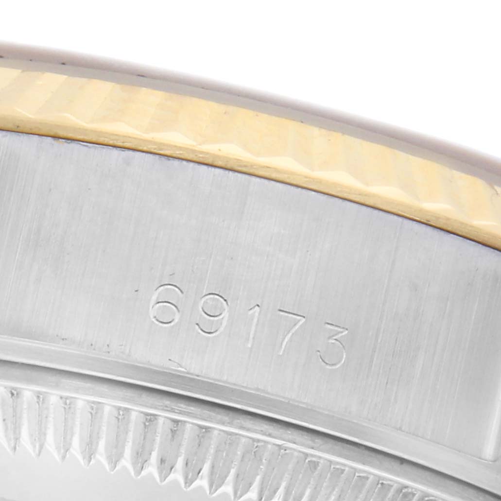 The image shows a close-up of the side of a Rolex Datejust 69173 Women
s Steel and Gold (two tone) Champagne Dial 69173 Women
s Steel and Gold (two tone) Champagne Dial, highlighting the model number engraving and part of the bezel.