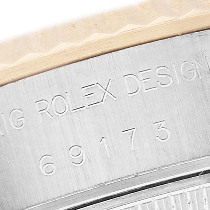 The image shows a close-up of the Rolex Datejust 69173 Women
s Steel and Gold (two tone) Champagne Dial 69173 Women
s Steel and Gold (two tone) Champagne Dial
s case side, featuring engraved text and numbers.
