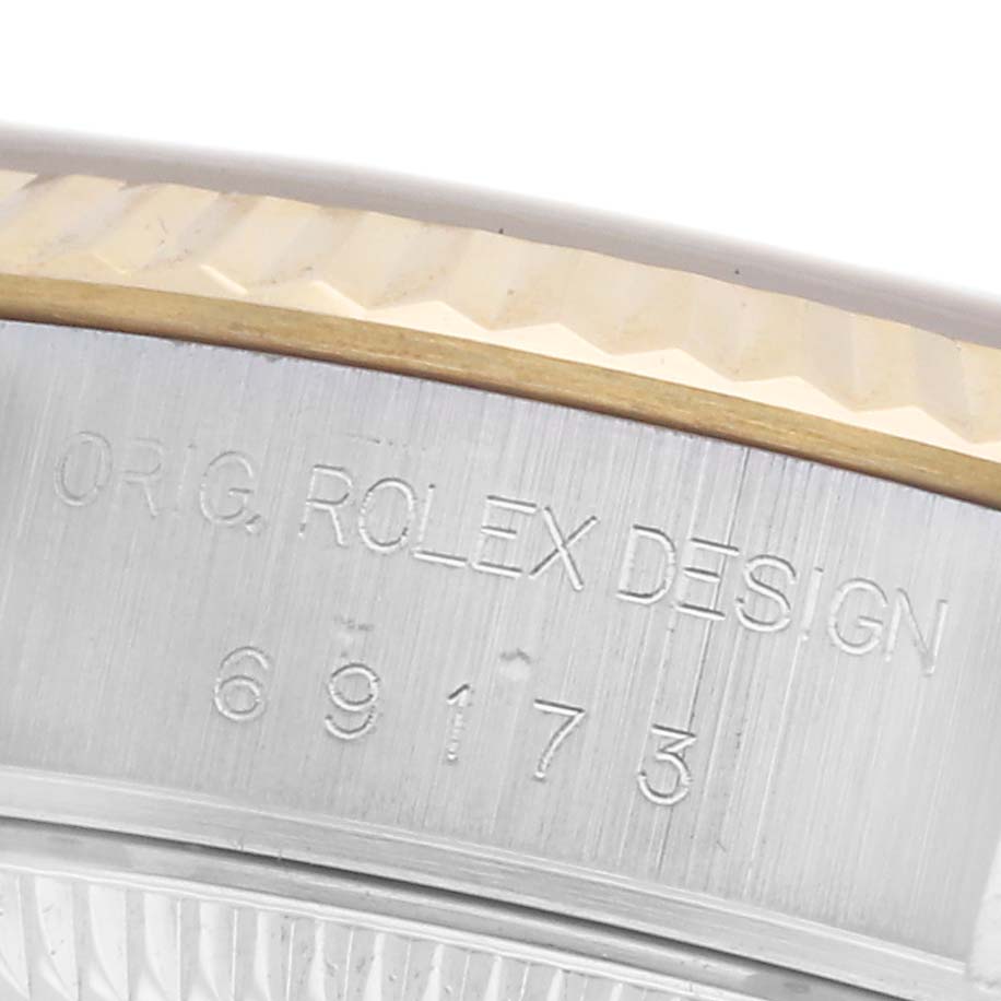 The image shows a close-up of the engraved side of a Rolex Datejust 69173 Women
s Steel and Gold (two tone) Champagne Dial 69173 Women
s Steel and Gold (two tone) Champagne Dial, featuring its bezel and model number.
