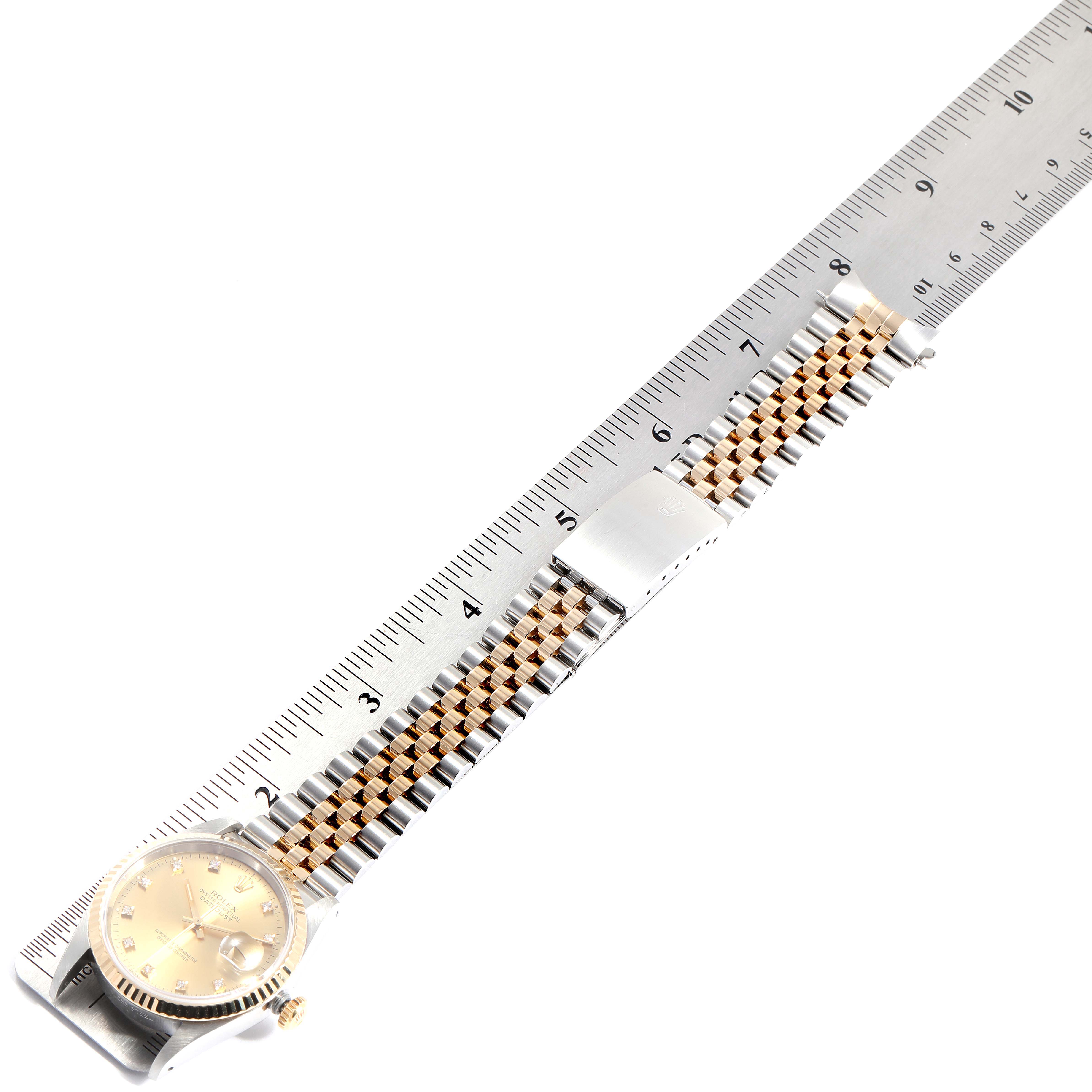 The image shows a Rolex Datejust 16233 Men
s Steel and Gold (two tone) Champagne Dial 16233 Men
s Steel and Gold (two tone) Champagne Dial watch laid flat, displaying its dial, bezel, two-tone bracelet, and clasp alongside a ruler.