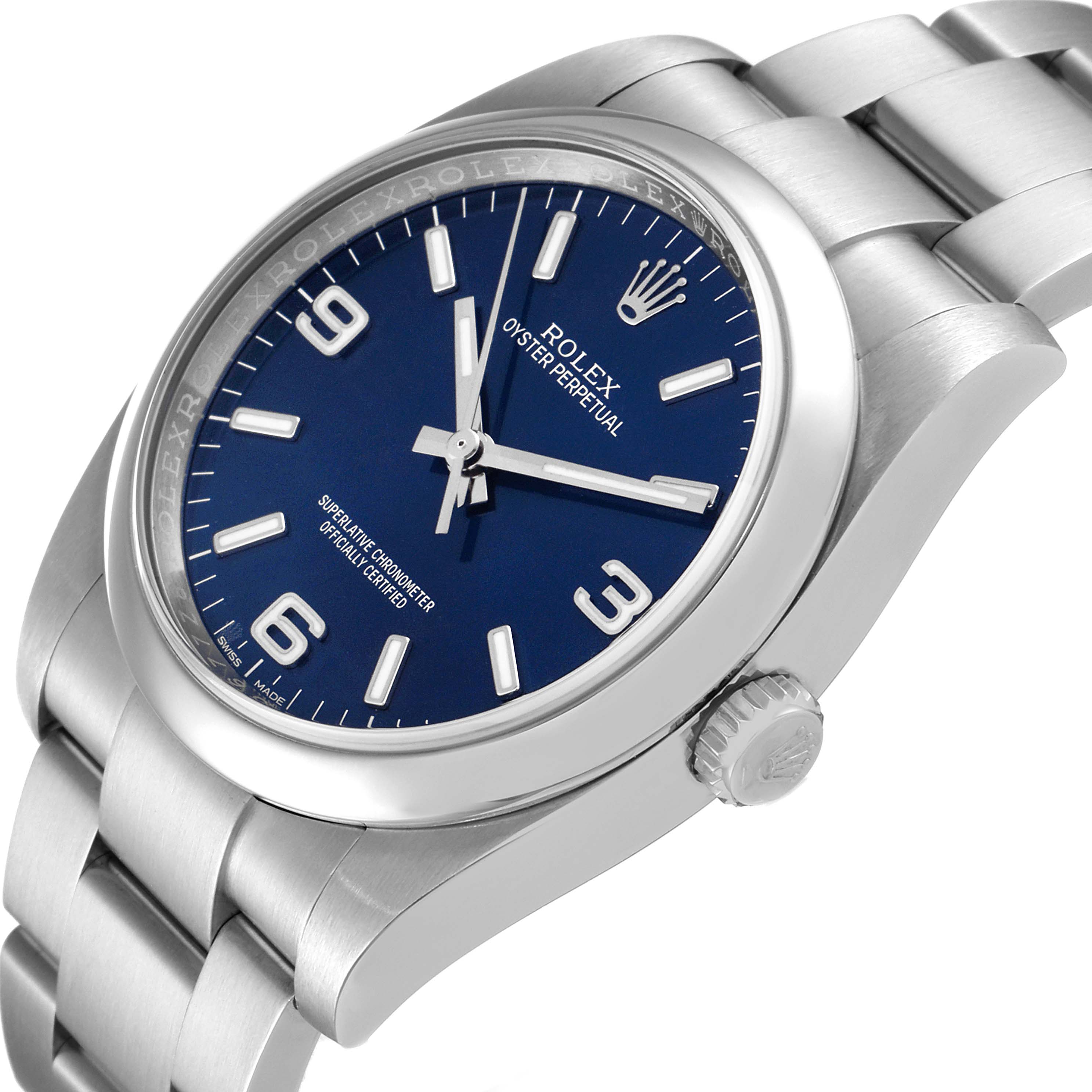 The Rolex Oyster Perpetual 116000 Men's Stainless Steel Blue Dial 116000 Men's Stainless Steel Blue Dial watch is shown at an angle highlighting the blue dial, bezel, bracelet, and crown.