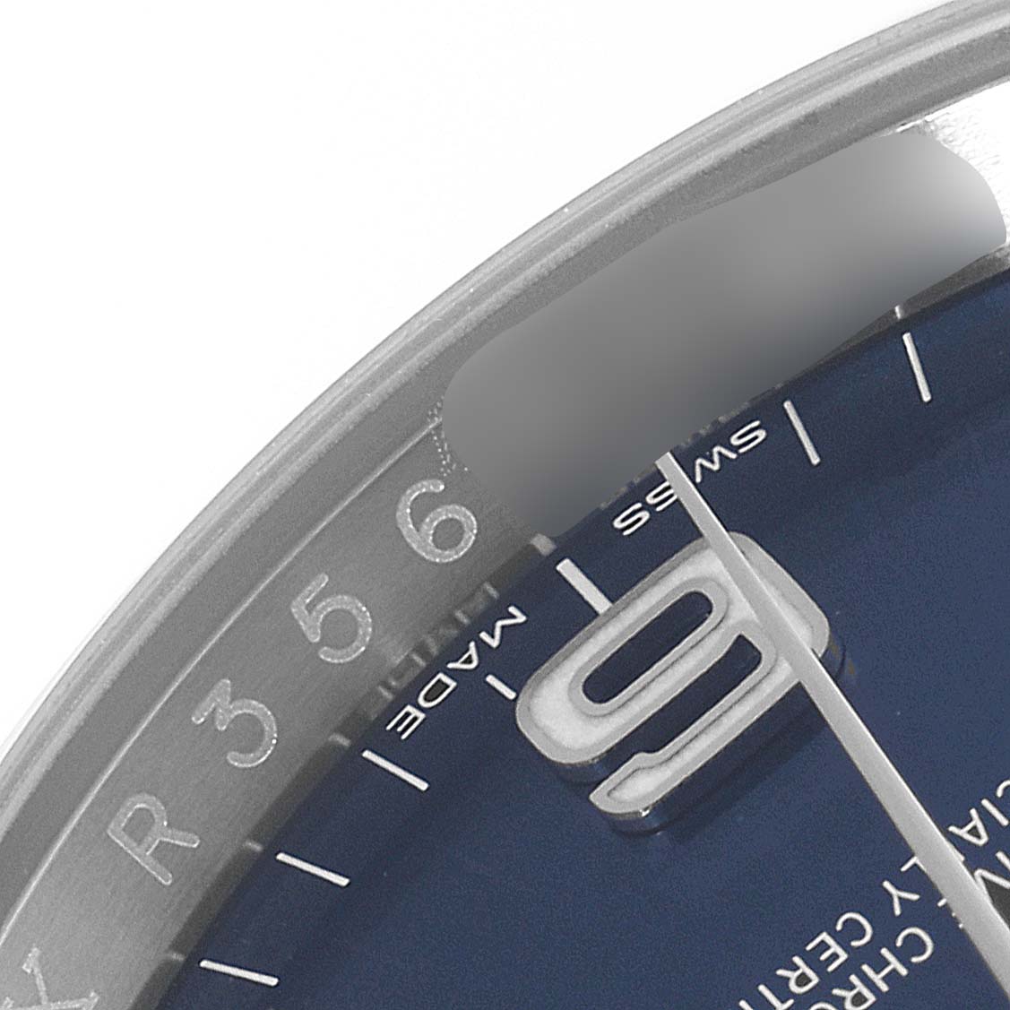 This image shows a close-up of the dial and bezel of a Rolex Oyster Perpetual 116000 Men's Stainless Steel Blue Dial 116000 Men's Stainless Steel Blue Dial watch, highlighting the 9 o'clock marker and part of the second hand.