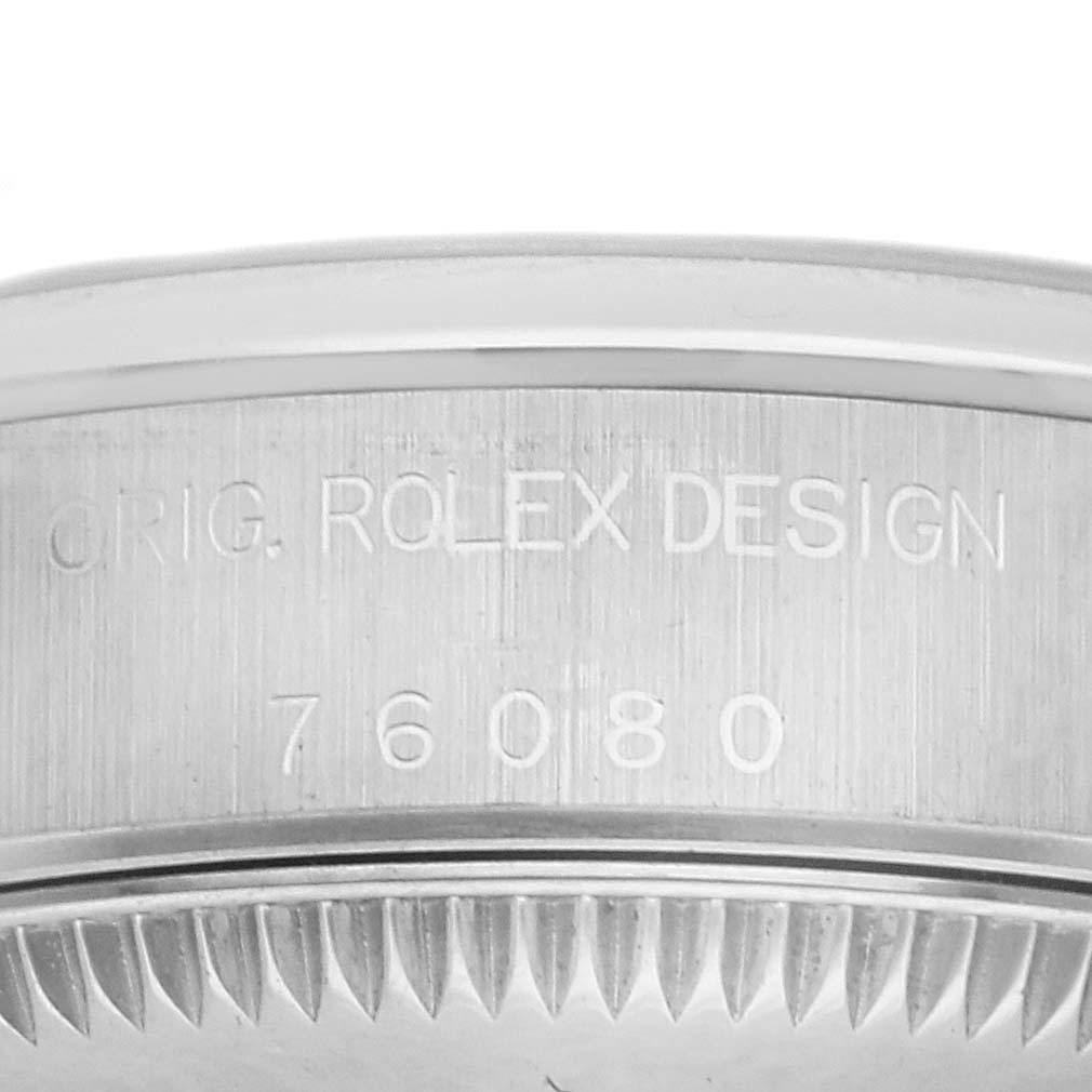 The image shows a side view of the case edge and serial number engraving of the Rolex Oyster Perpetual 76080 Women
s Stainless Steel Black Dial 76080 Women
s Stainless Steel Black Dial.