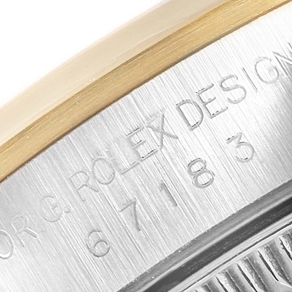 This close-up image of a Rolex Oyster Perpetual 67183 Women's Steel and Gold (two tone) Grey Dial 67183 Women's Steel and Gold (two tone) Grey Dial watch shows part of the inscription on its stainless steel case-back.
