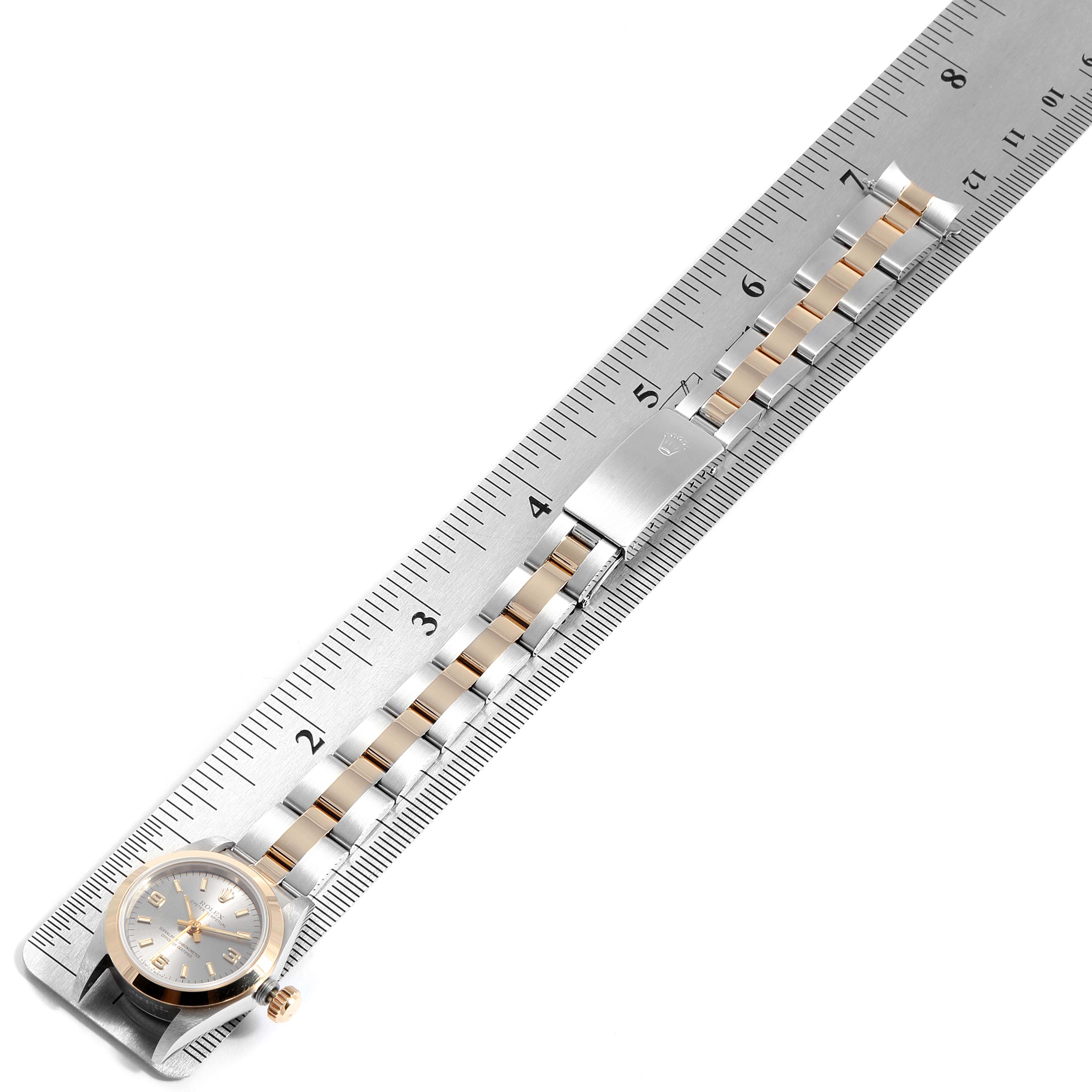 The image shows a Rolex Oyster Perpetual 67183 Women's Steel and Gold (two tone) Grey Dial 67183 Women's Steel and Gold (two tone) Grey Dial watch laid flat, with its bracelet aligned along a ruler for measurement.