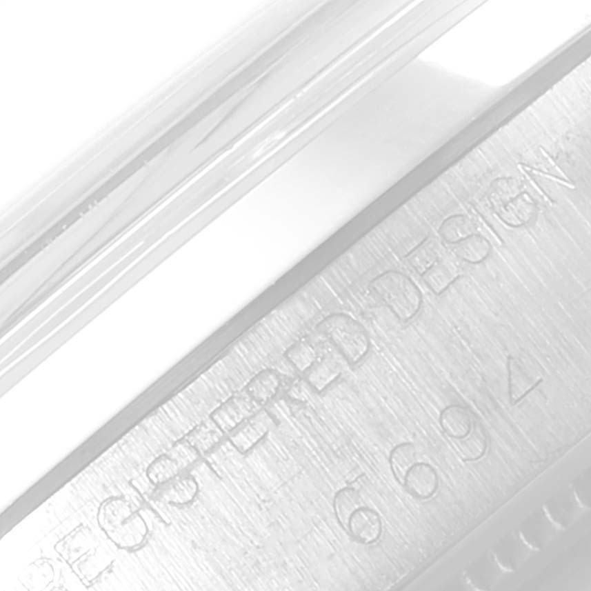 The image shows a close-up of the case exterior of a Rolex Date 6694 Men's Stainless Steel Black Dial 6694 Men's Stainless Steel Black Dial model watch, featuring "REGISTERED DESIGN" engraving.