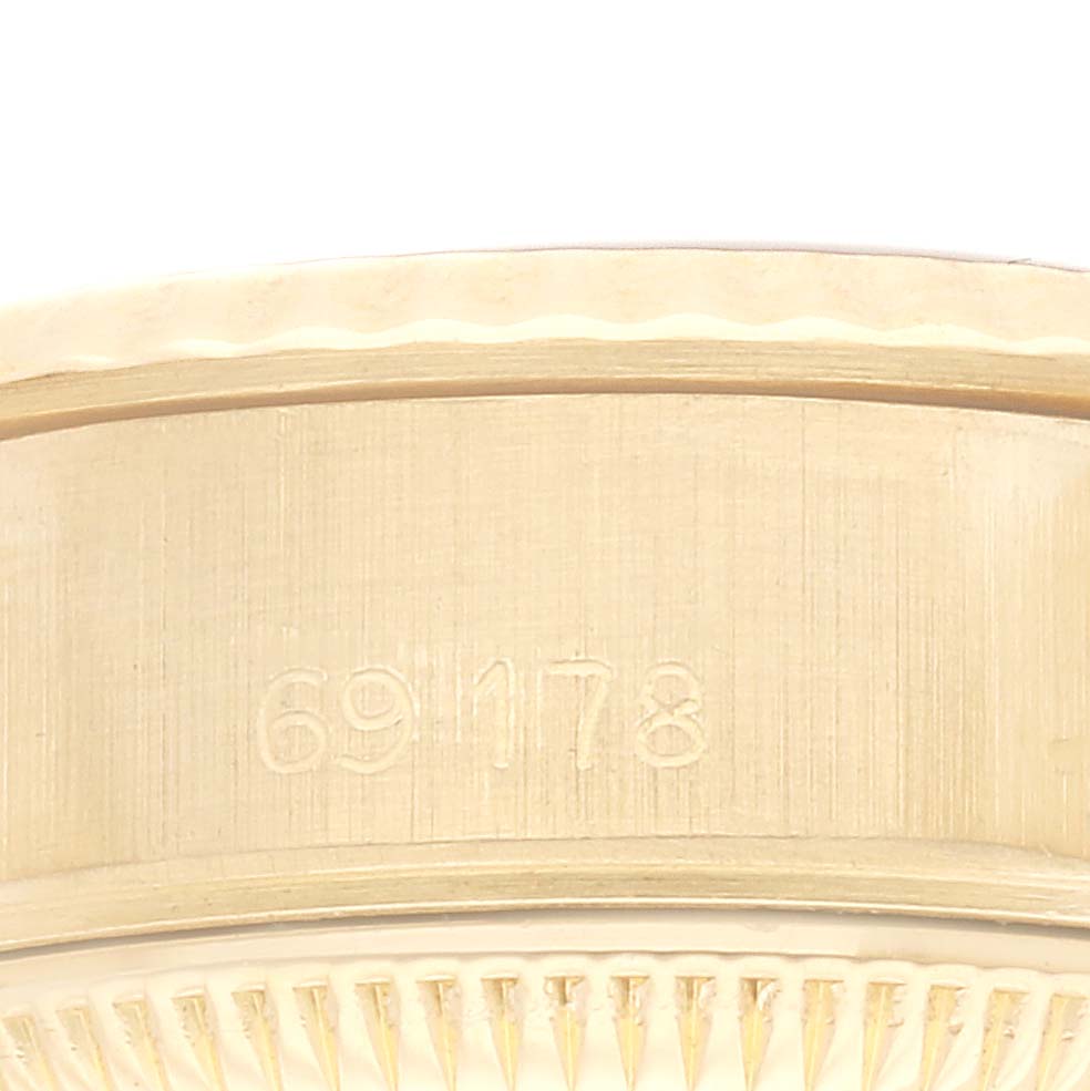 The image shows a close-up of the side of the bezel and case of the Rolex President 69178 Women
s Yellow Gold Blue Dial 69178 Women
s Yellow Gold Blue Dial, featuring engravings on its edge.