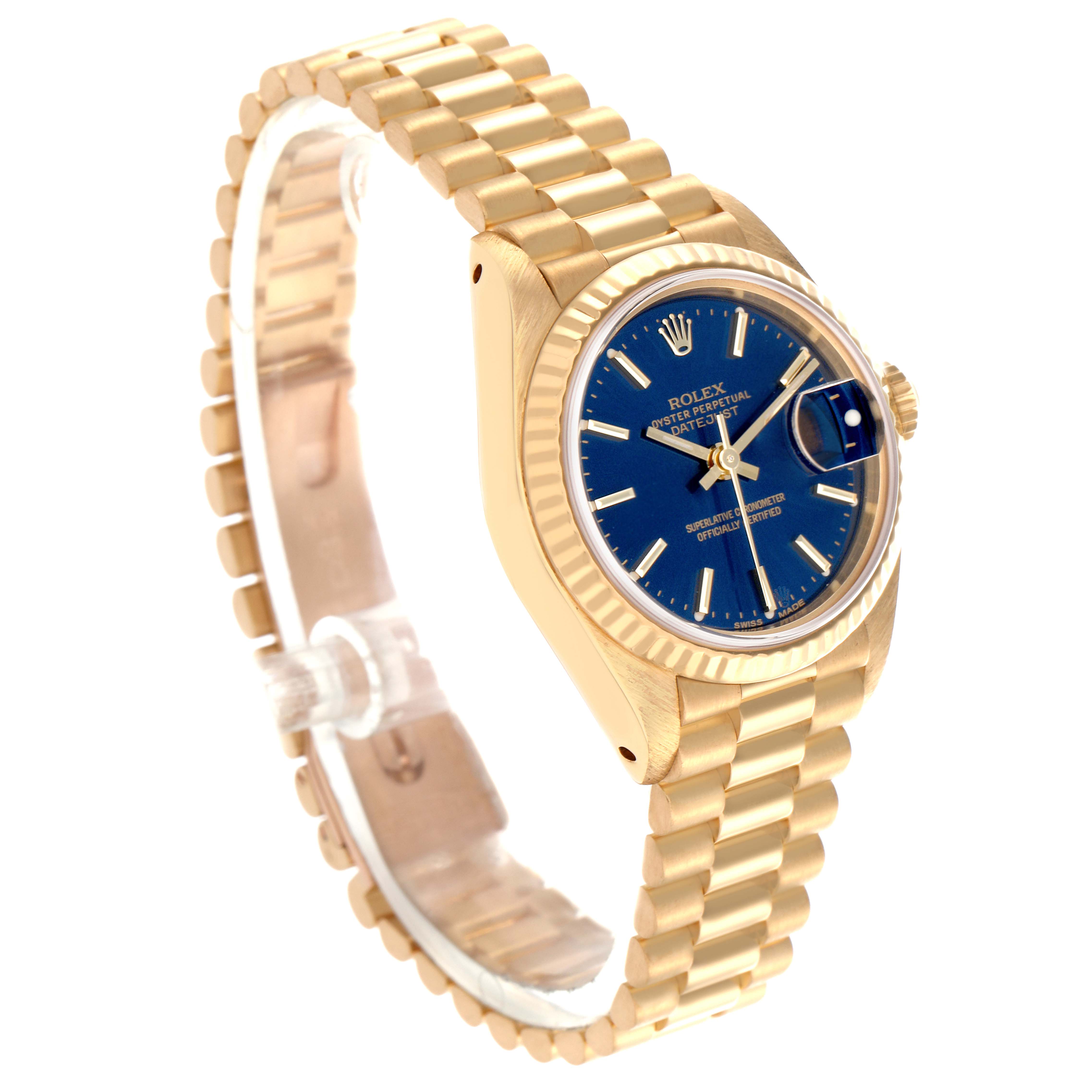 The image shows a Rolex President 69178 Women
s Yellow Gold Blue Dial 69178 Women
s Yellow Gold Blue Dial model watch at an angled side view, displaying its blue dial, fluted bezel, and linked bracelet.