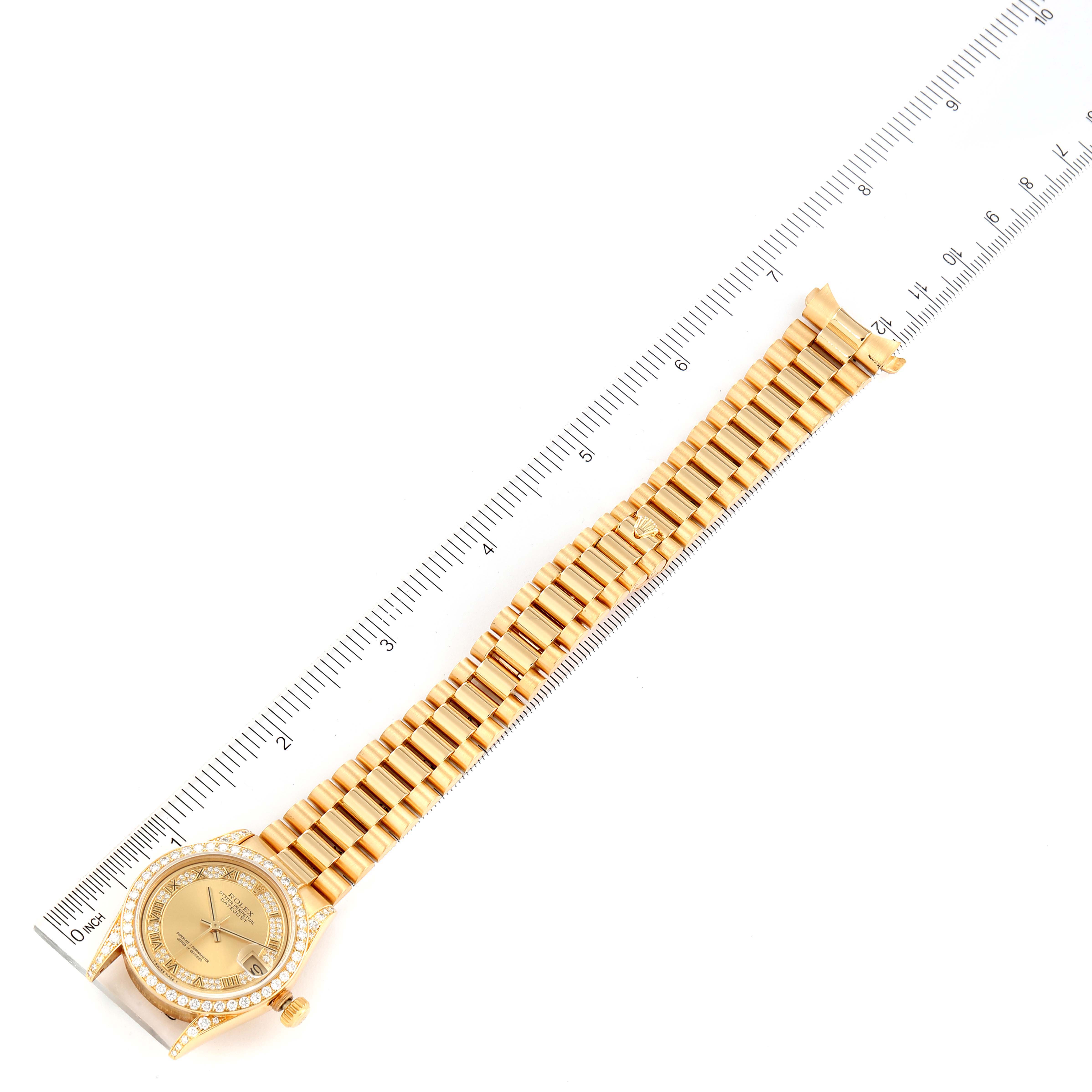 The image shows a gold Rolex President 68158 Women
s Yellow Gold Champagne Dial 68158 Women
s Yellow Gold Champagne Dial model watch with its face, bezel, and bracelet alongside a ruler for scale.