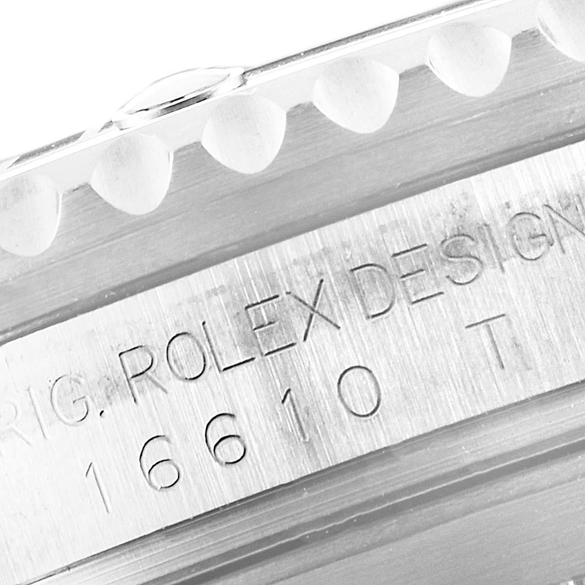 The image shows a close-up of the Rolex Submariner 16610 Men's Stainless Steel Black Dial 16610 Men's Stainless Steel Black Dial model, focusing on the engraved side and part of the bezel.