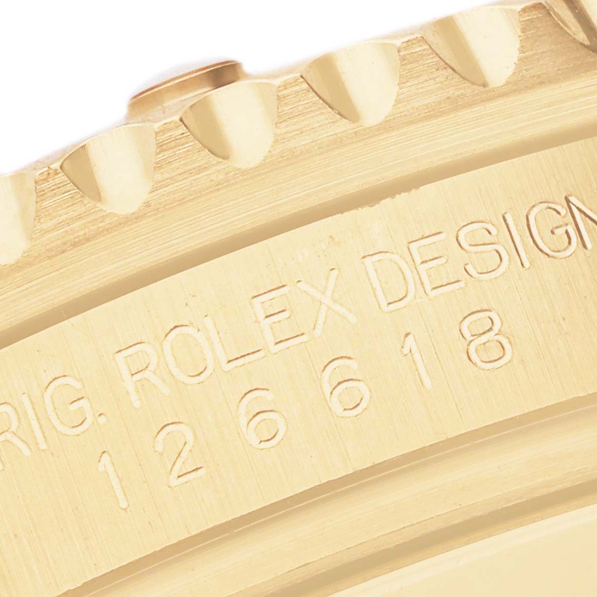 This close-up image shows the engraved model number and design details on the bezel of a Rolex Submariner 126618LB Men's Yellow Gold Blue Dial 126618LB Men's Yellow Gold Blue Dial.