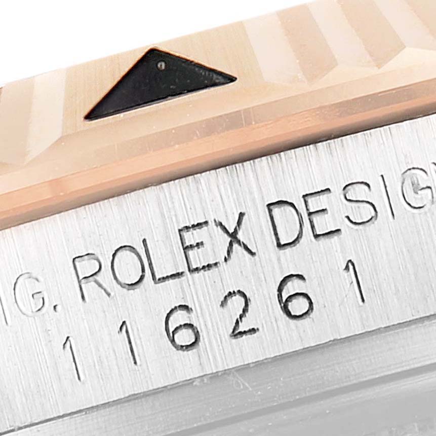 The image shows a close-up of the bezel and casing of a Rolex Turn-o-Graph 116261 Men
s Steel and Gold (two tone) Black Dial 116261 Men
s Steel and Gold (two tone) Black Dial watch, featuring part of the serial number and "Rolex Design" engraving.