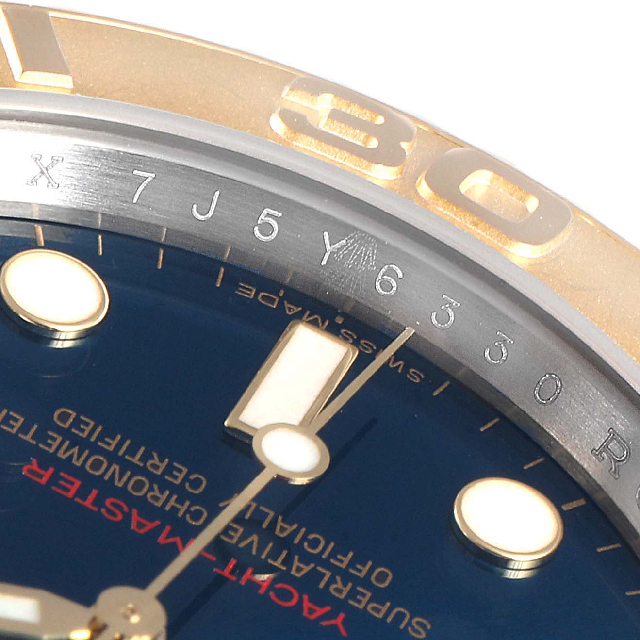 This close-up of a Rolex Yacht-Master 16623 Men
s Steel and Gold (two tone) Blue Dial 16623 Men
s Steel and Gold (two tone) Blue Dial watch shows the edge of the bezel, part of the dial, and some hour markers.