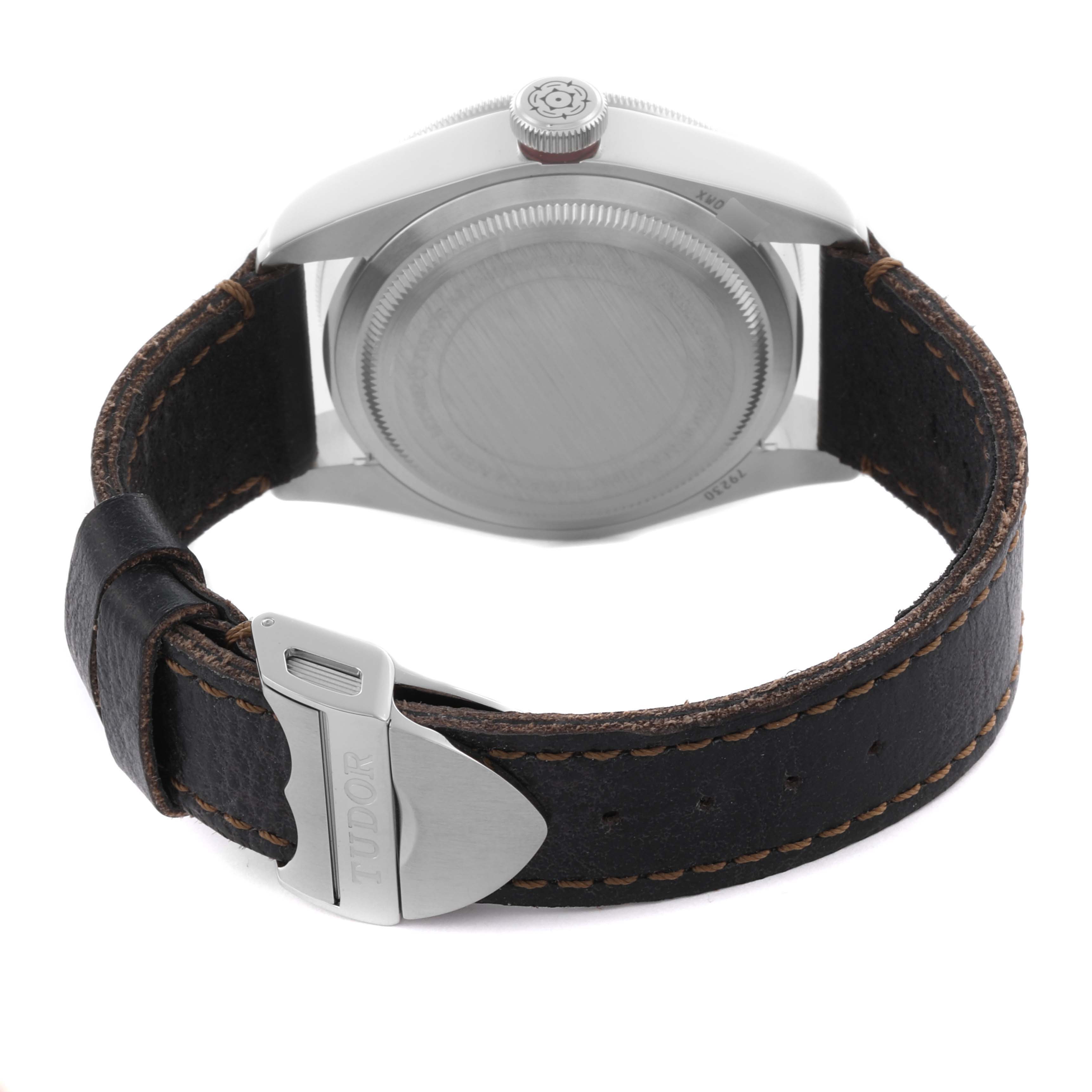 The image shows the Tudor Heritage Black Bay 79230R-0011 Men
s Stainless Steel Black Dial 79230R-0011 Men
s Stainless Steel Black Dial from the back, displaying the case back and leather strap with a metal clasp.