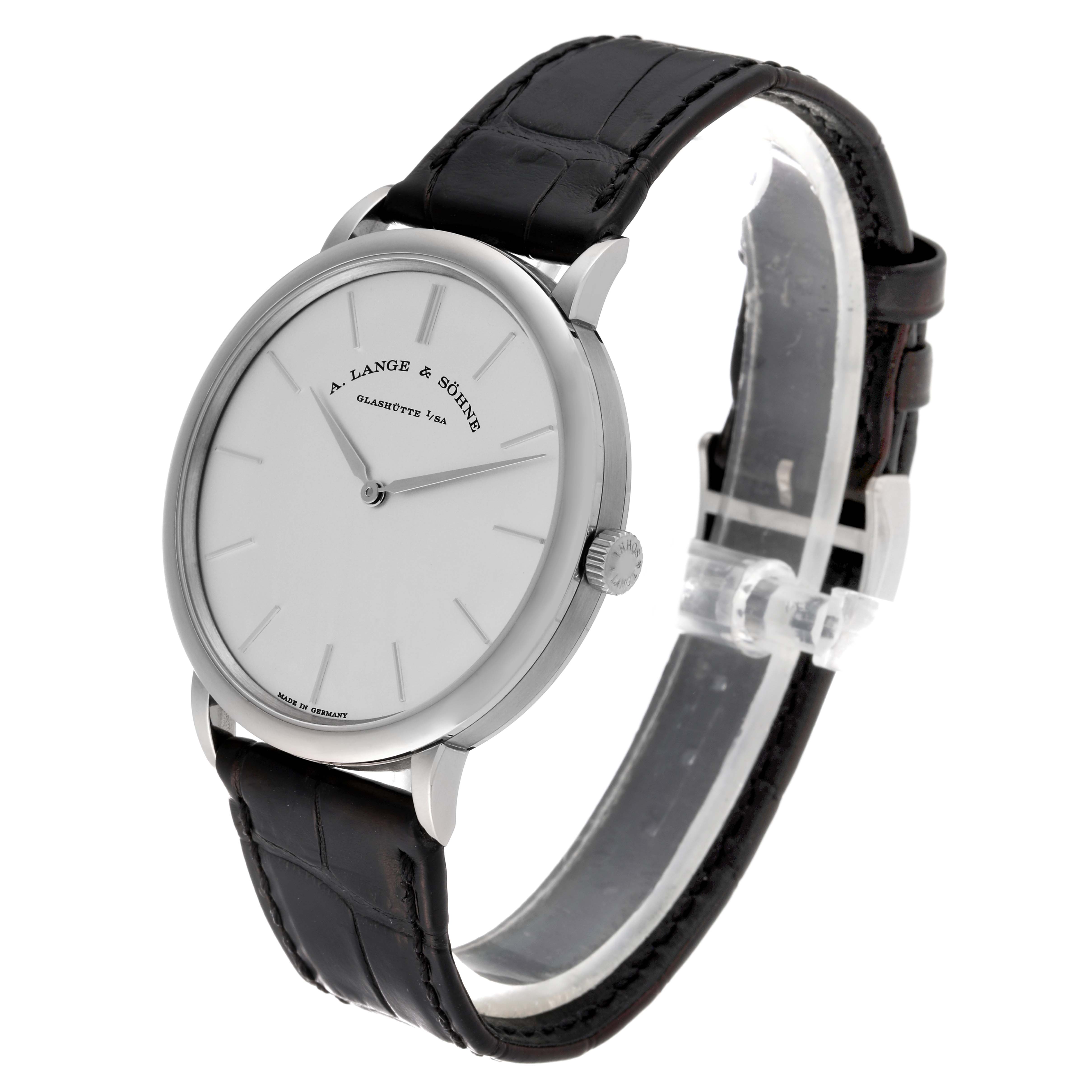 The image shows the A. Lange 
Sohne Saxonia 211.027 Men
s White Gold Silver Dial watch at a three-quarter angle, displaying its dial, bezel, and leather strap.