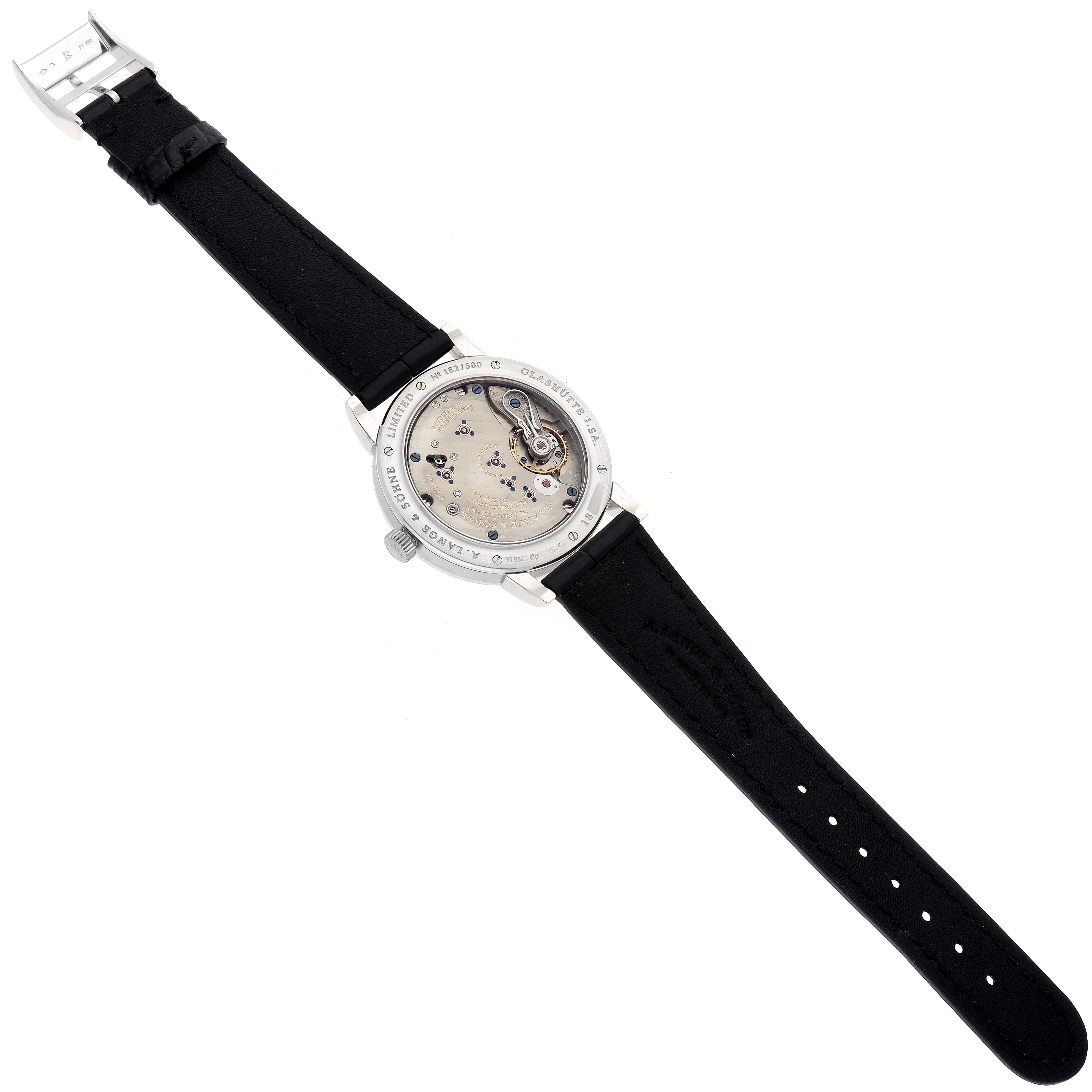 The image shows the back view of an 1815 model watch by A. Lange & Söhne, highlighting the watch mechanism and black leather strap.