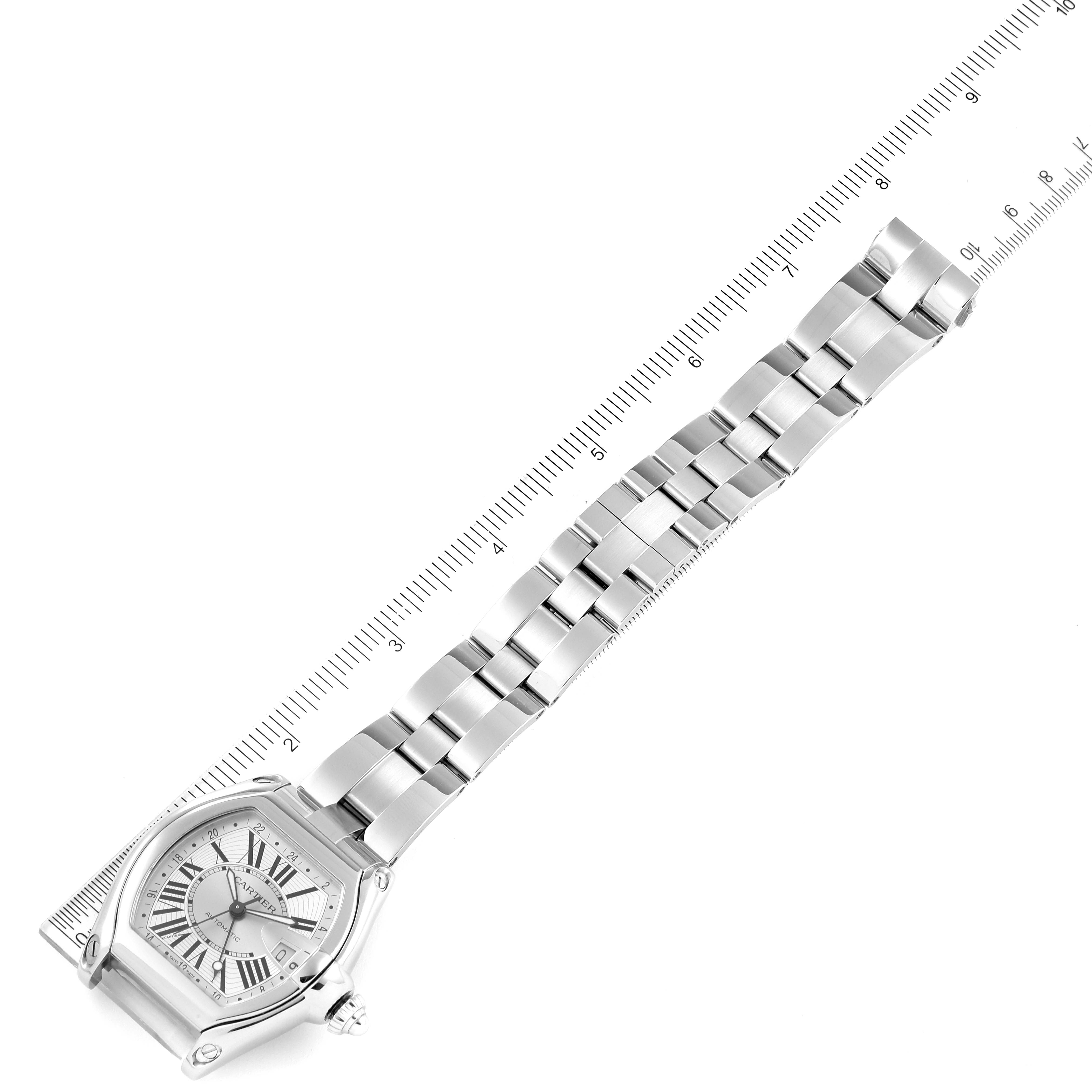 The image shows a Cartier Roadster W62032X6 Men's Stainless Steel Silver Dial W62032X6 Men's Stainless Steel Silver Dial watch laid flat, highlighting its face, bracelet, and part of the clasp with a ruler beside it.