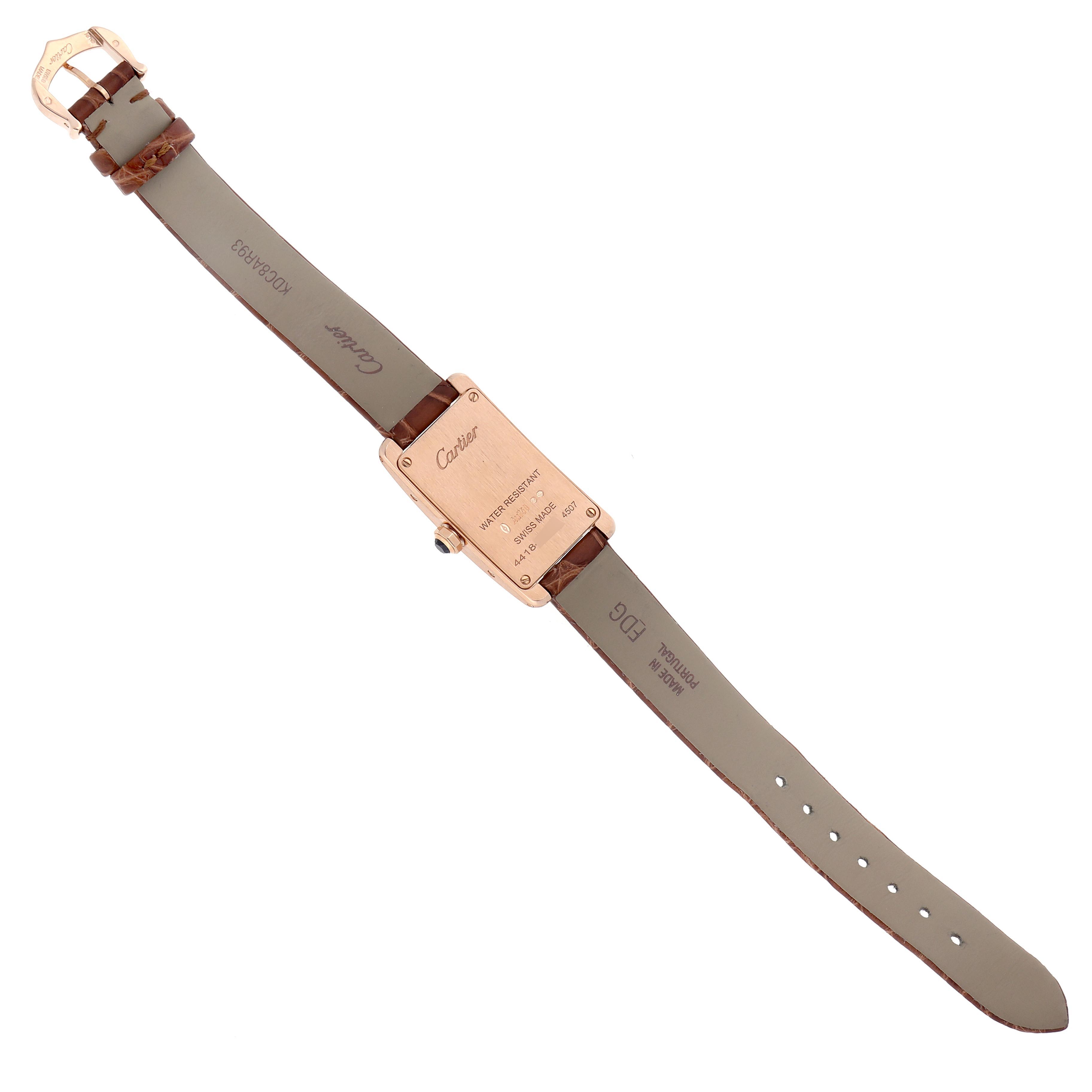 The Cartier Tank Americaine W2607456 Women
s Rose Gold Silver Dial W2607456 Women
s Rose Gold Silver Dial watch is shown from the back, displaying its rectangular case, strap, and clasp.