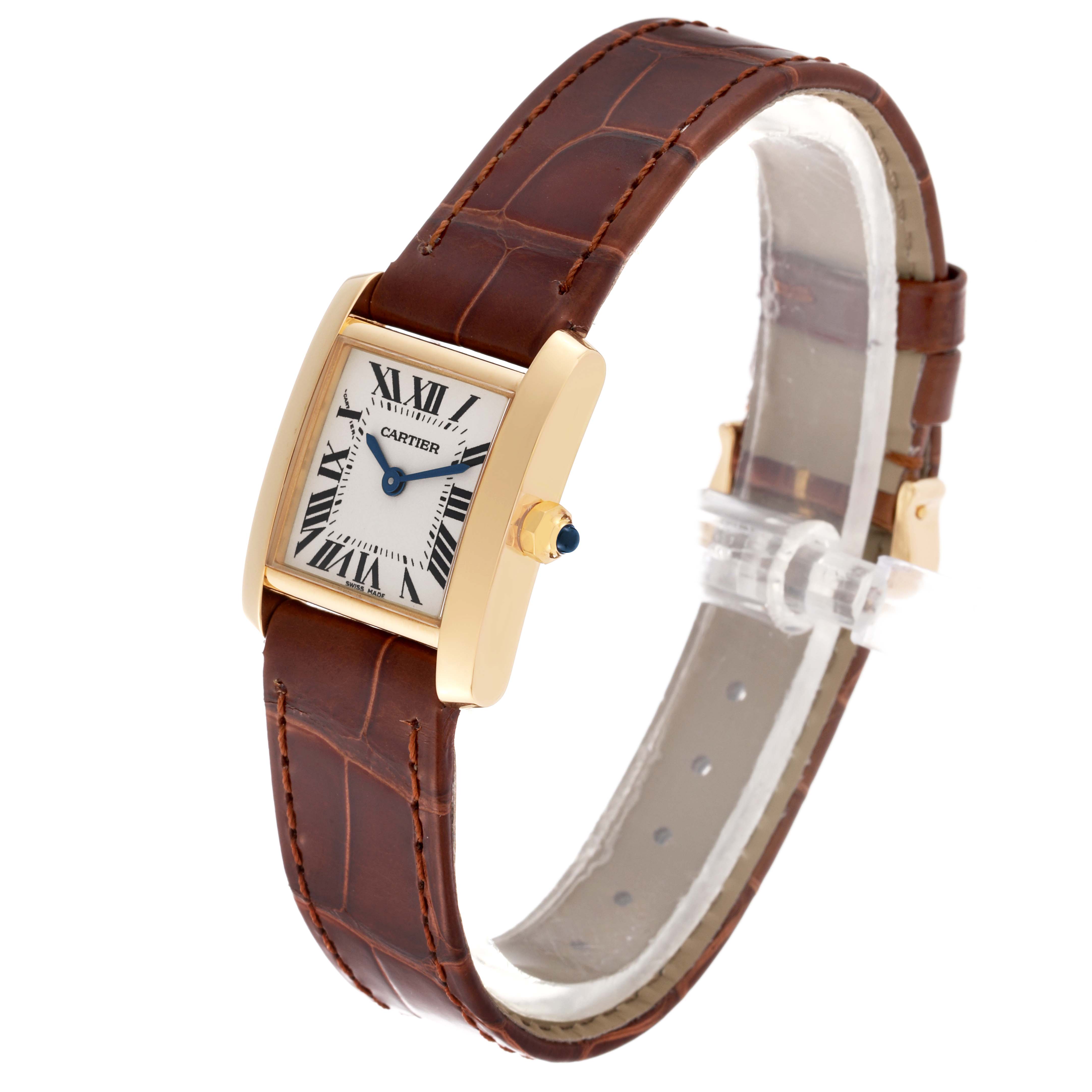 The Cartier Tank Francaise W5000256 Women
s Yellow Gold Silver Dial W5000256 Women
s Yellow Gold Silver Dial watch is shown at an angled side view, displaying its gold case, Roman numeral dial, and brown leather strap.