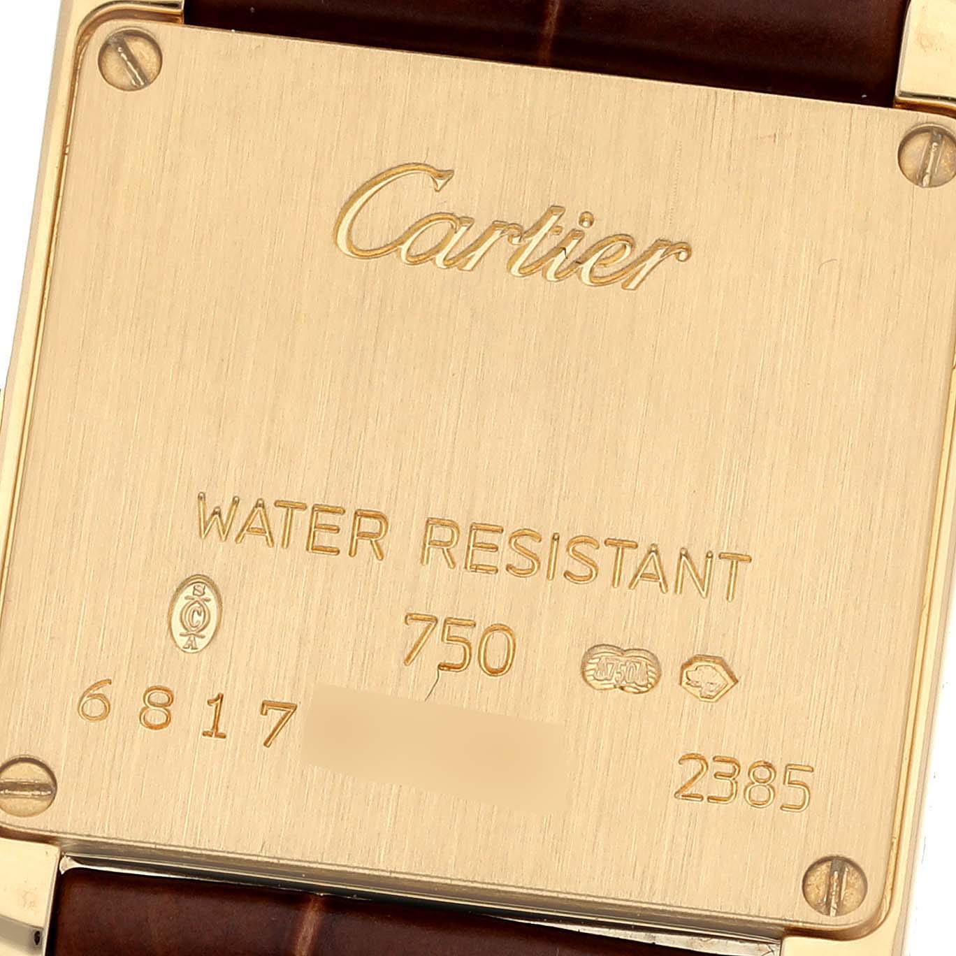 The image shows the back case of a Cartier Tank Francaise W5000256 Women
s Yellow Gold Silver Dial W5000256 Women
s Yellow Gold Silver Dial watch, displaying engravings and screws.