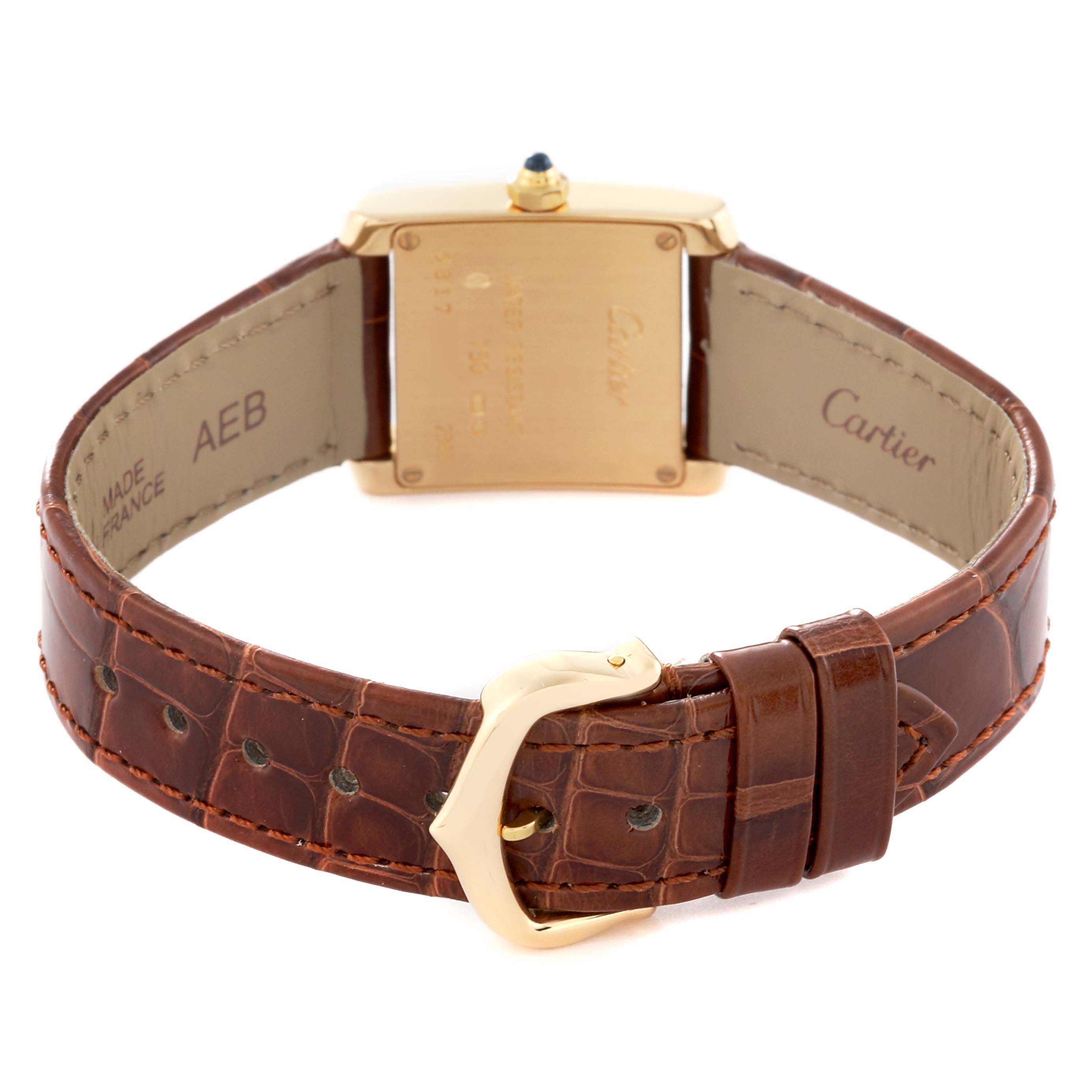 The image shows the back view of the Cartier Tank Francaise W5000256 Women
s Yellow Gold Silver Dial W5000256 Women
s Yellow Gold Silver Dial watch with a brown leather strap and gold buckle.