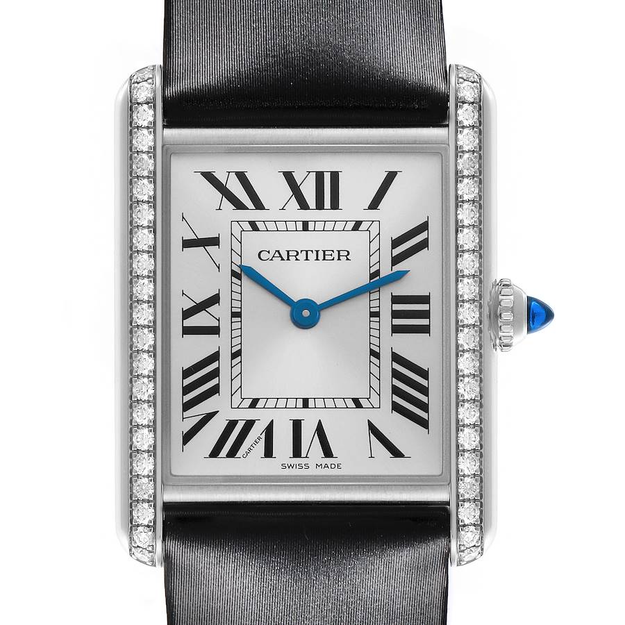 The Cartier Tank Must watch is shown from a front view, highlighting the face, Roman numerals, blue hands, diamond bezel, and crown detail.