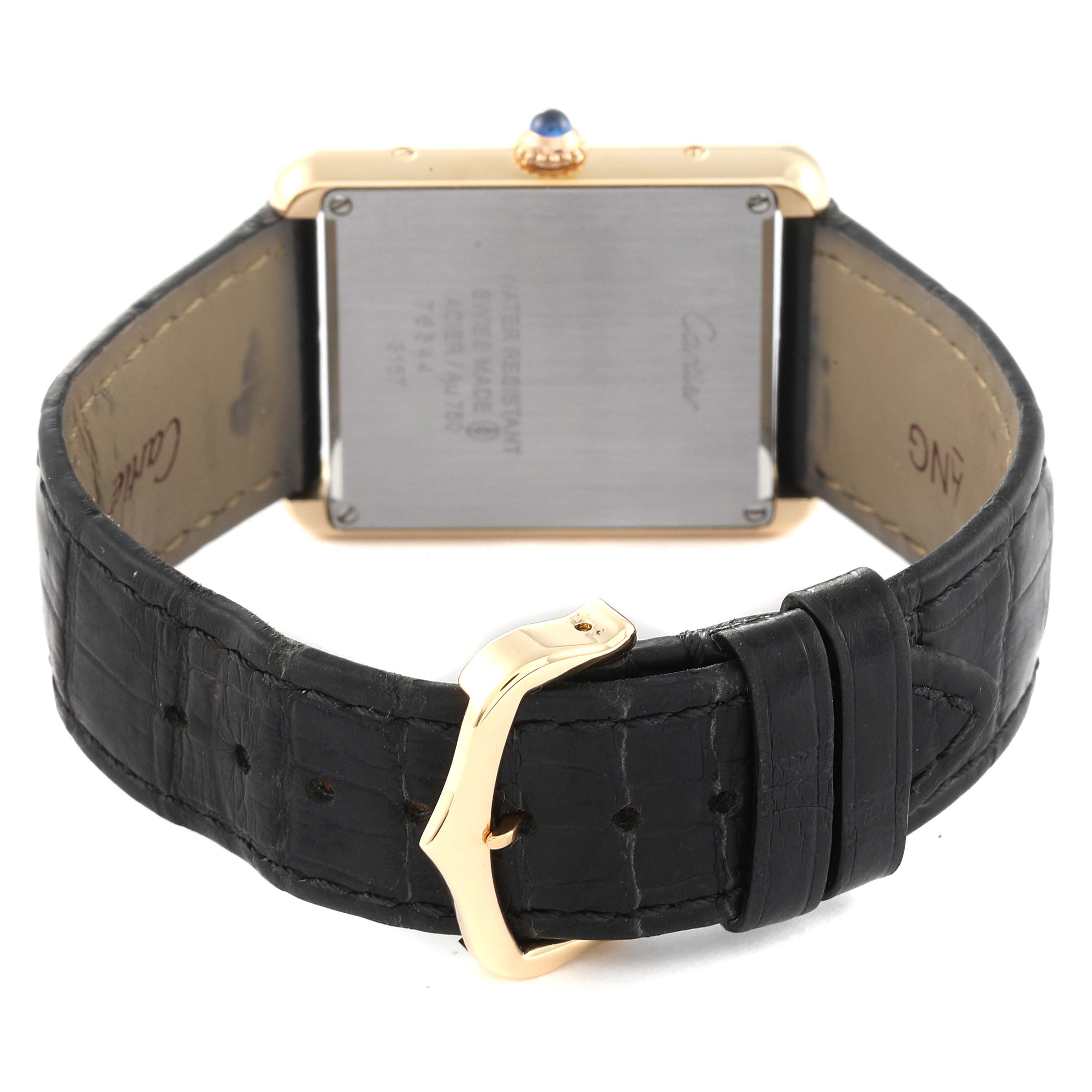 The image shows the back side of a Cartier Tank Solo W5200004 Men
s Yellow Gold Silver Dial W5200004 Men
s Yellow Gold Silver Dial watch, focusing on the case back and the leather strap with a buckle.