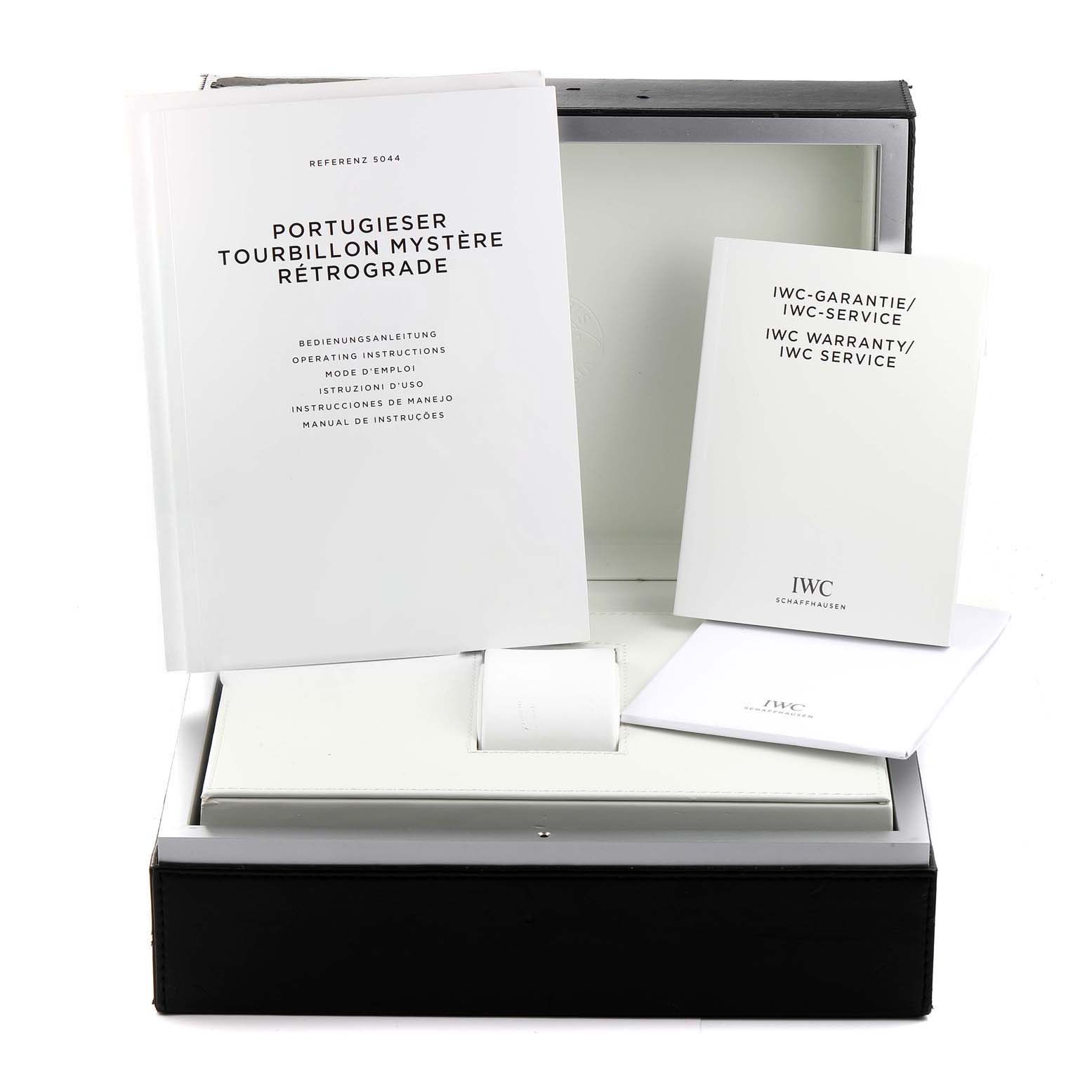 The image shows the box, manual, and warranty card for the IWC Portugieser Tourbillon Mystère Rétrograde watch.