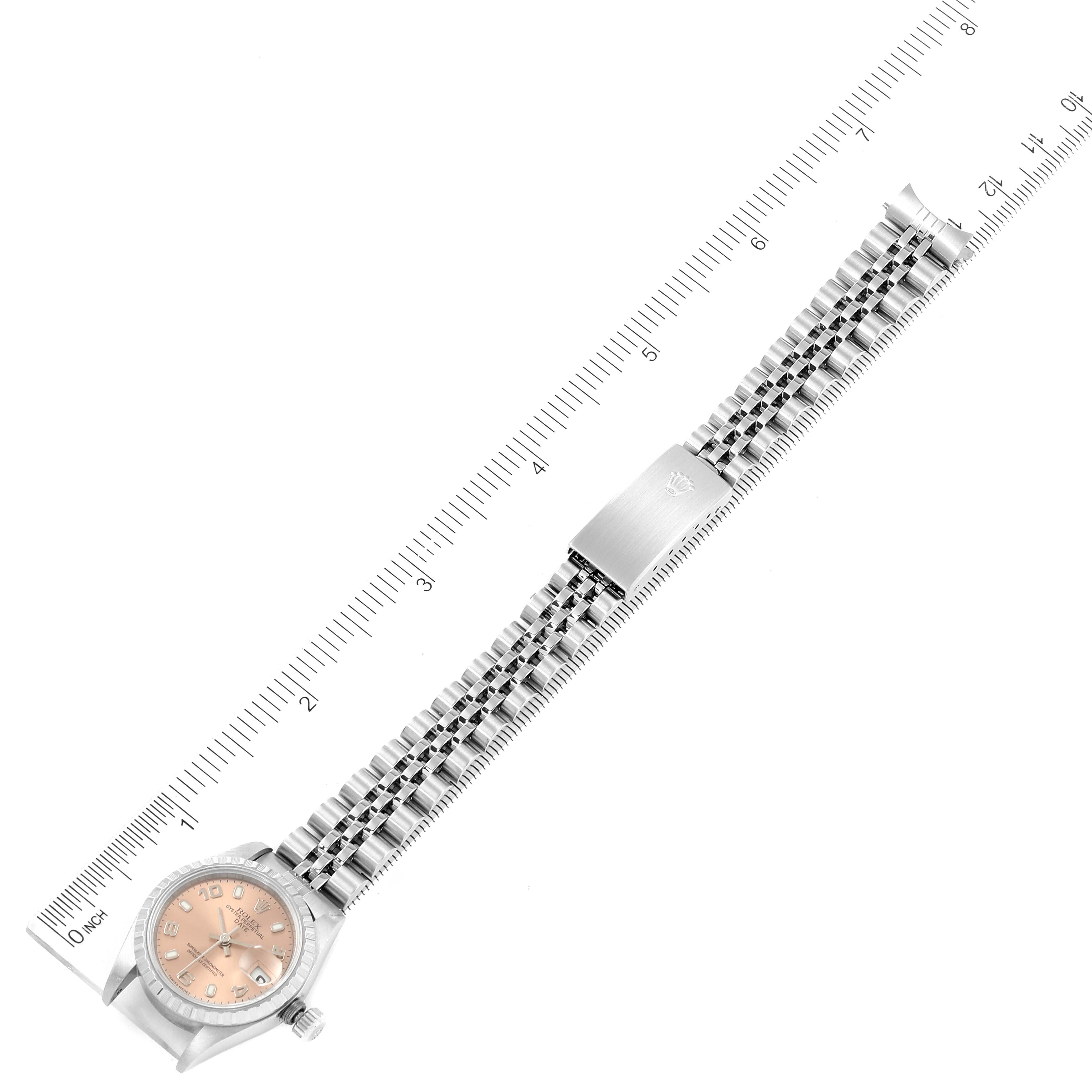 The image shows a top-down view of a Rolex Date 79240 Women's Stainless Steel Pink Dial 79240 Women's Stainless Steel Pink Dial model watch, displaying the face, bracelet, and clasp against a ruler.