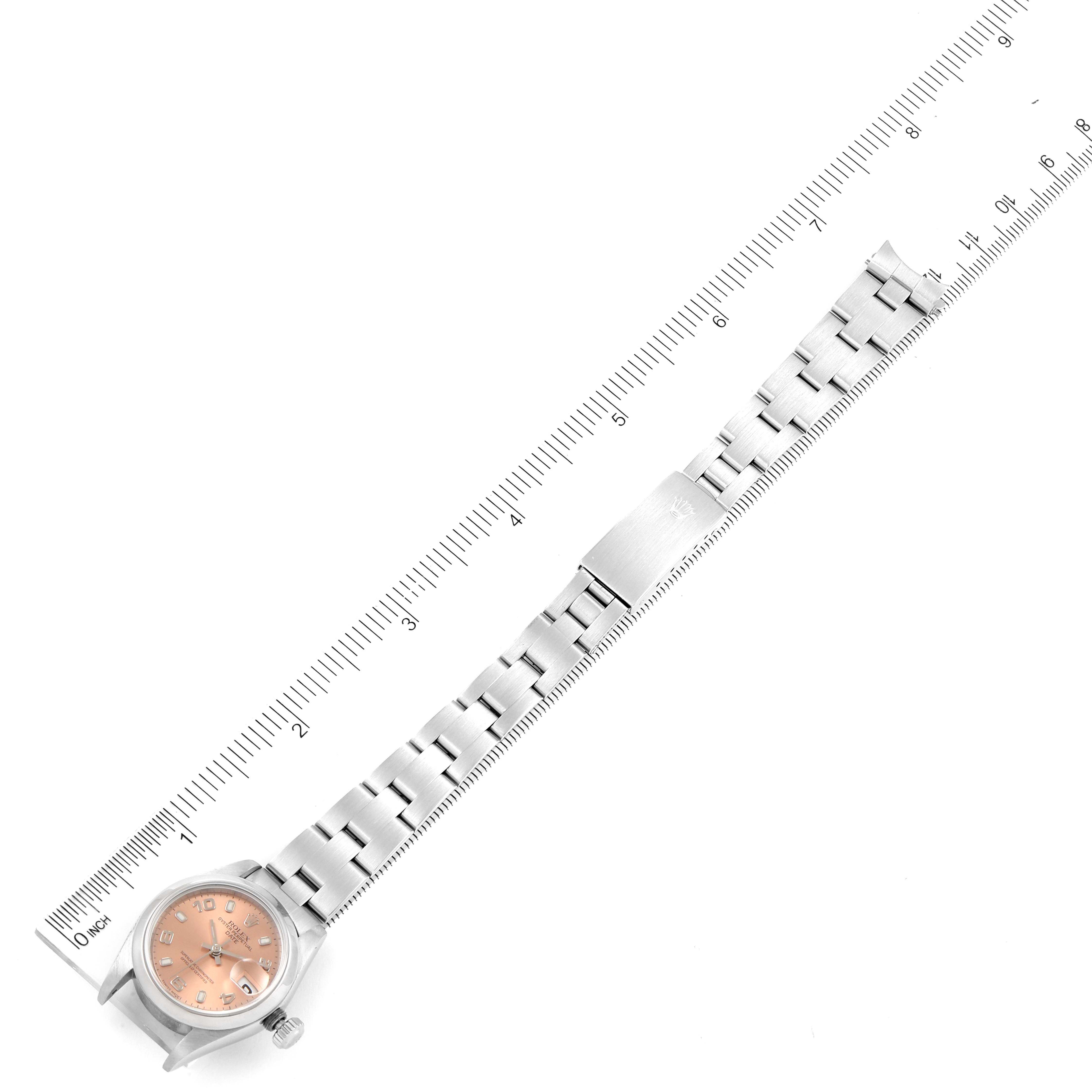 The image shows a Rolex Date 69160 Women's Stainless Steel Pink Dial 69160 Women's Stainless Steel Pink Dial model watch laid flat next to a ruler, displaying the face, bracelet, and clasp.