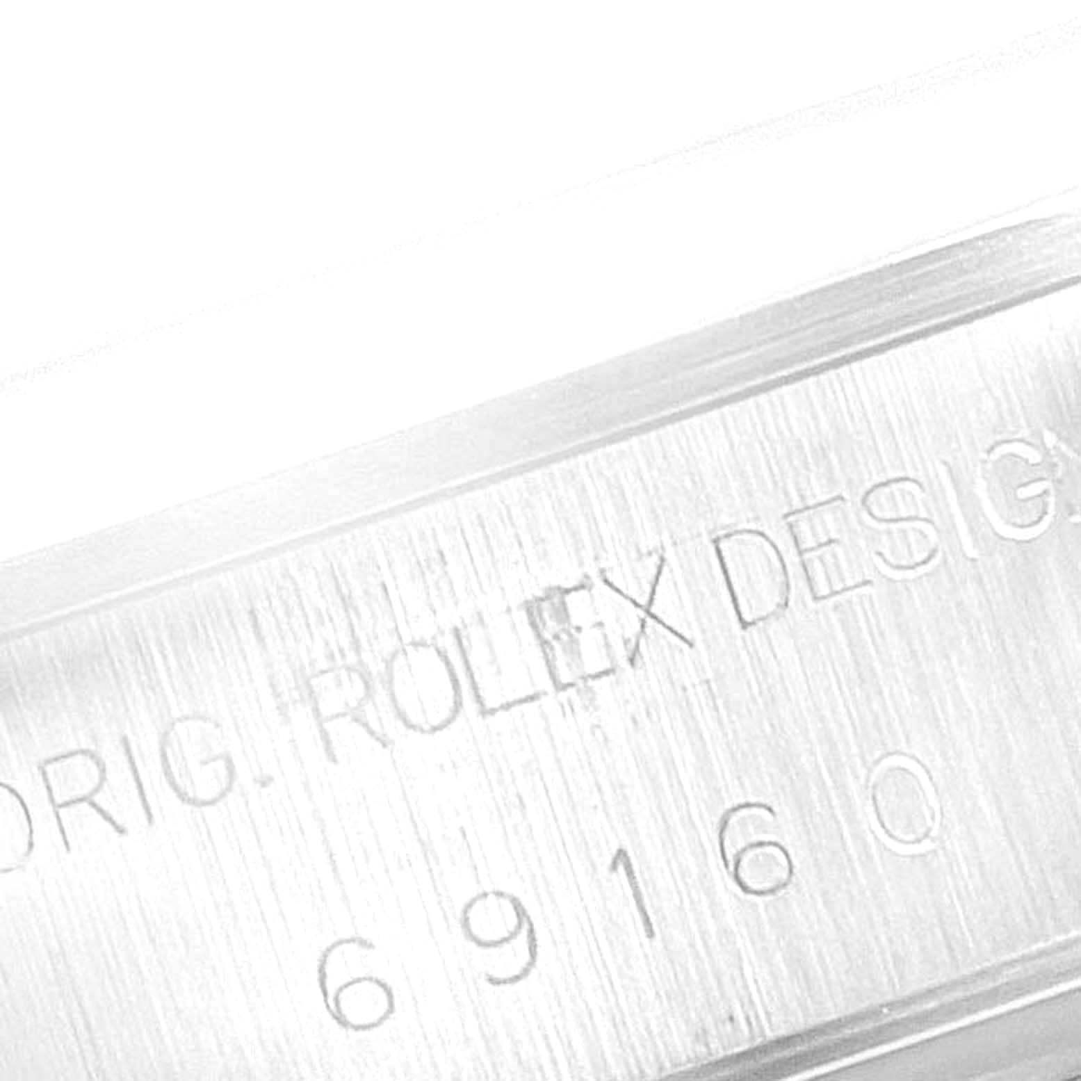 The image shows a close-up of the case side of a Rolex Date 69160 Women's Stainless Steel Pink Dial 69160 Women's Stainless Steel Pink Dial model with engraved text.
