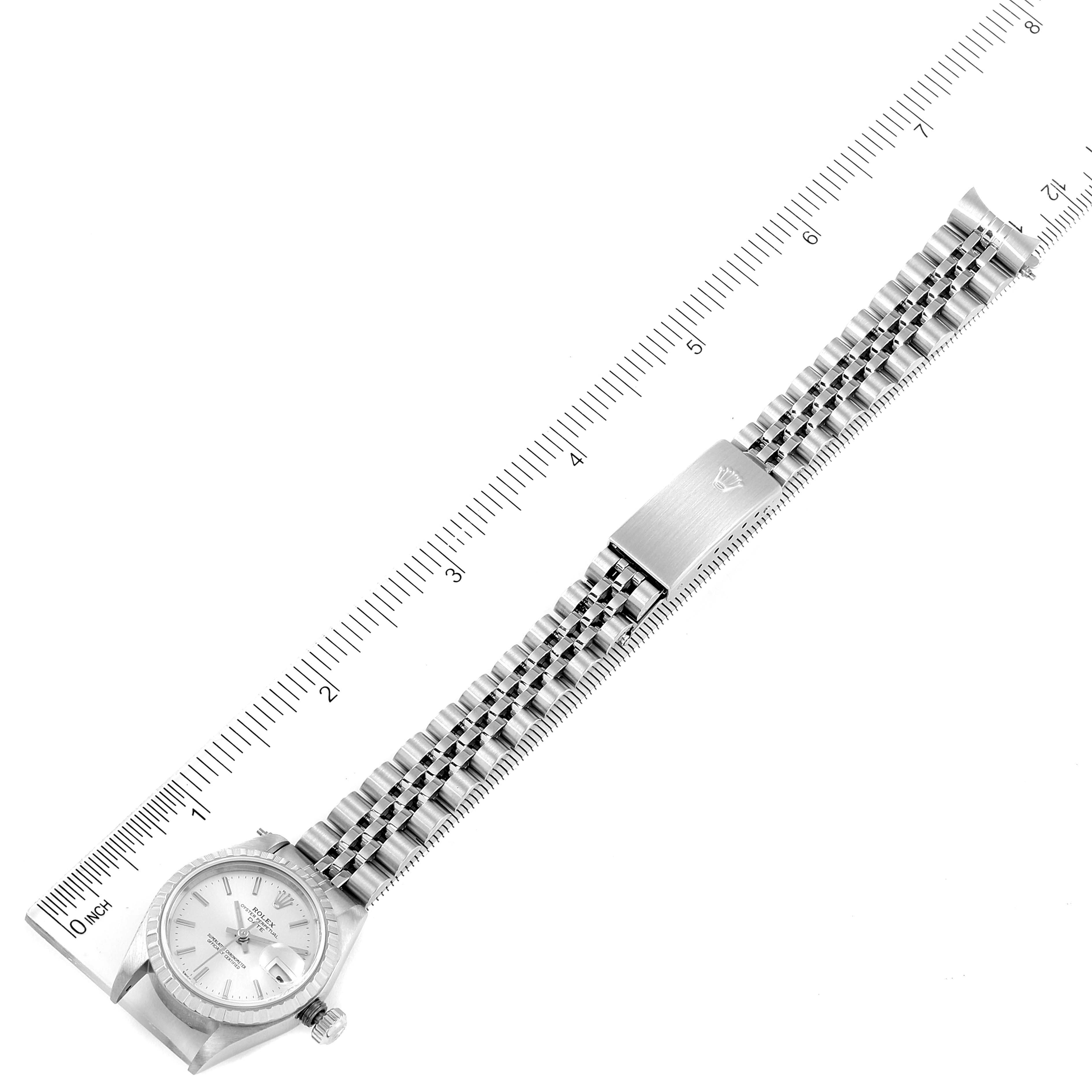 The image shows a top view of a Rolex Date 79240 Women
s Stainless Steel Silver Dial 79240 Women
s Stainless Steel Silver Dial model watch, including its face, bezel, crown, and the full bracelet with a ruler for scale.