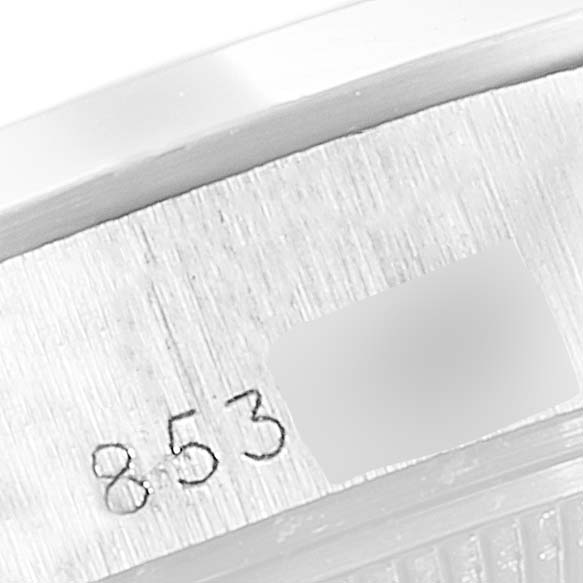 The image shows an angled close-up of the engraved serial number on a Rolex Date 69160 Women
s Stainless Steel Silver Dial 69160 Women
s Stainless Steel Silver Dial model watch case.
