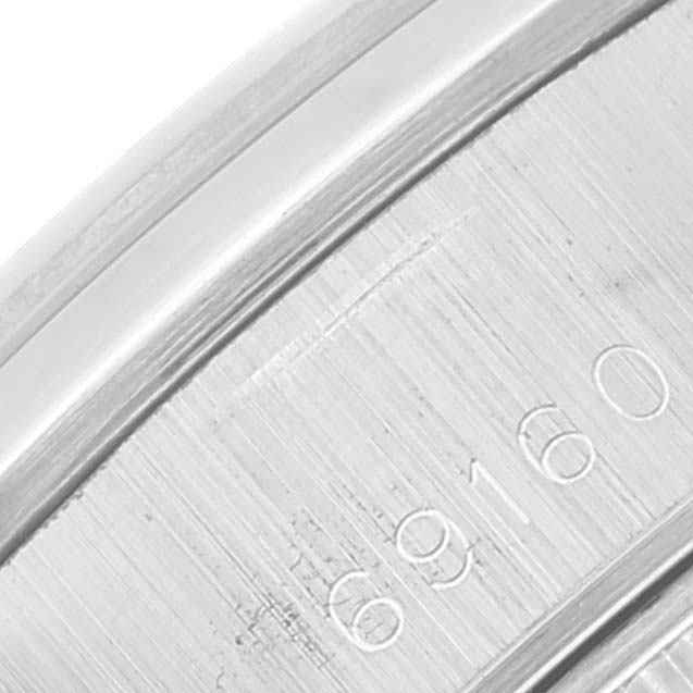 This image shows a close-up of the engraved serial number on the side of the case back of a Rolex Oyster Perpetual 69160 Women's Stainless Steel Silver Dial 69160 Women's Stainless Steel Silver Dial watch.