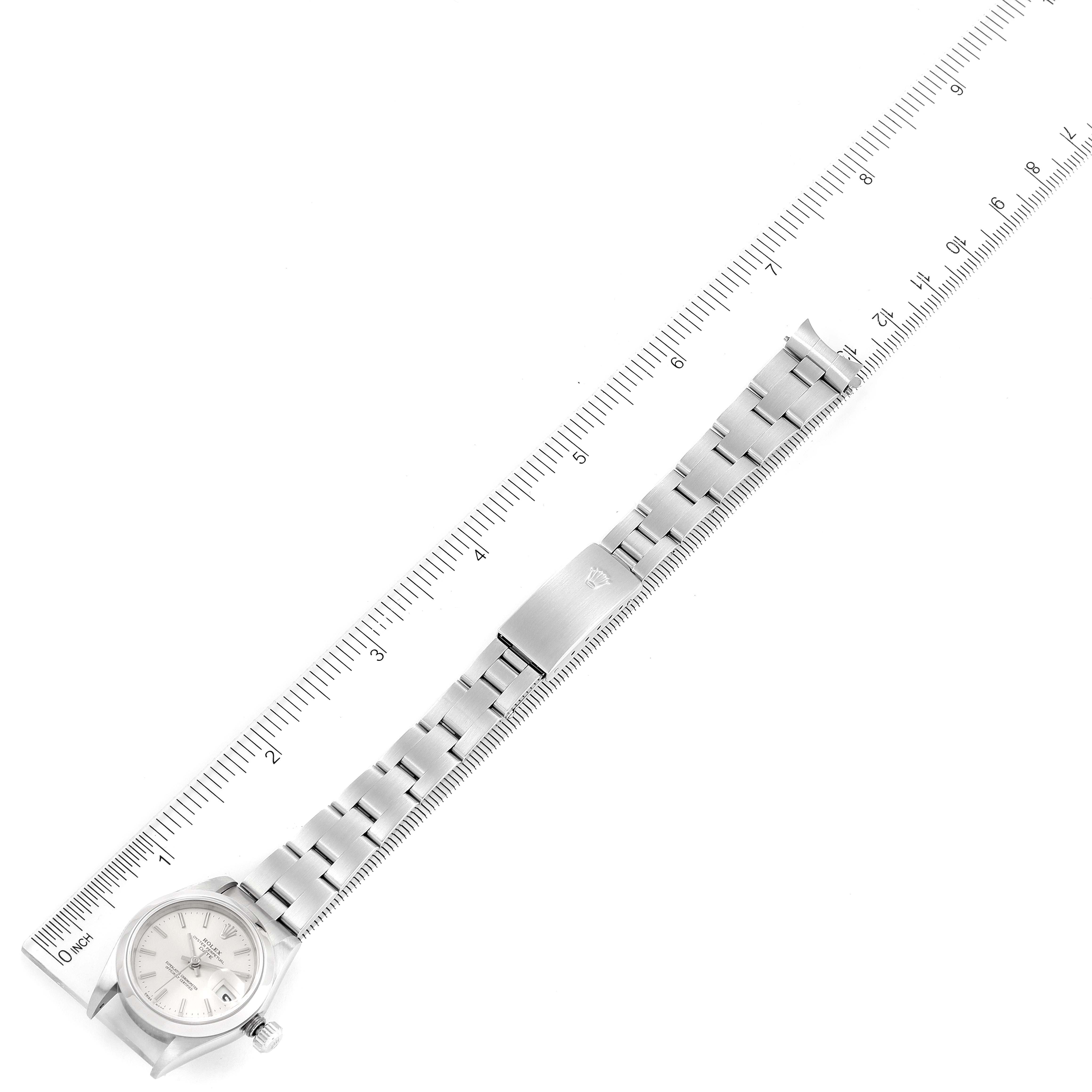 The Rolex Date 79160 Women
s Stainless Steel Silver Dial 79160 Women
s Stainless Steel Silver Dial watch is shown flat, revealing the face, bezel, crown, and full stainless-steel bracelet alongside a ruler.