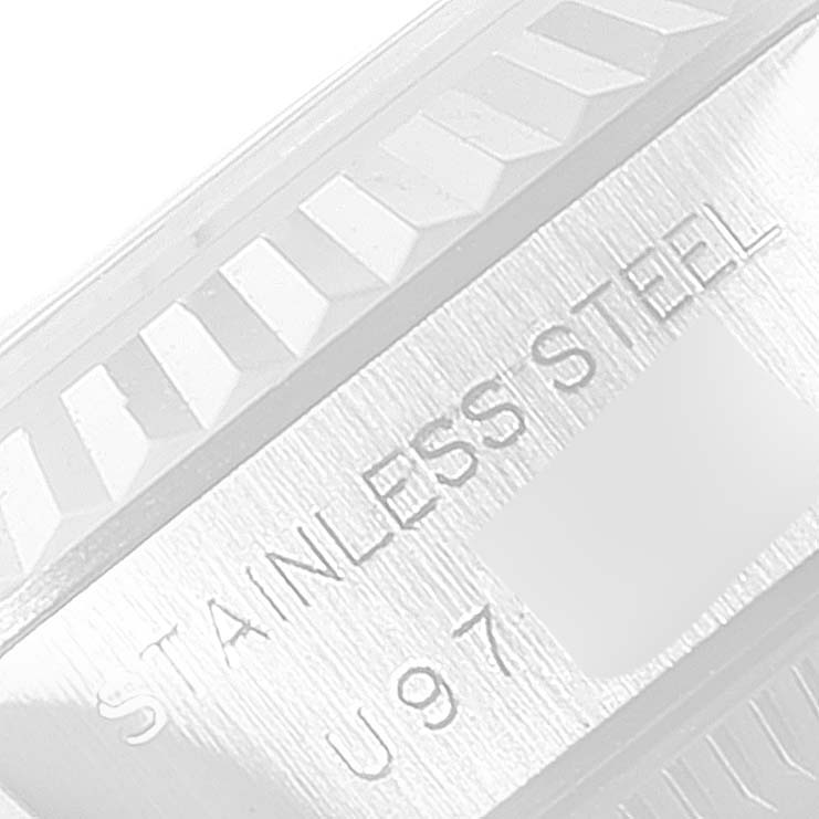 This image shows the close-up of the bezel and part of the casing of a Rolex Date 69174 Women
s Stainless Steel White Dial 69174 Women
s Stainless Steel White Dial model watch, with "STAINLESS STEEL" engraved.