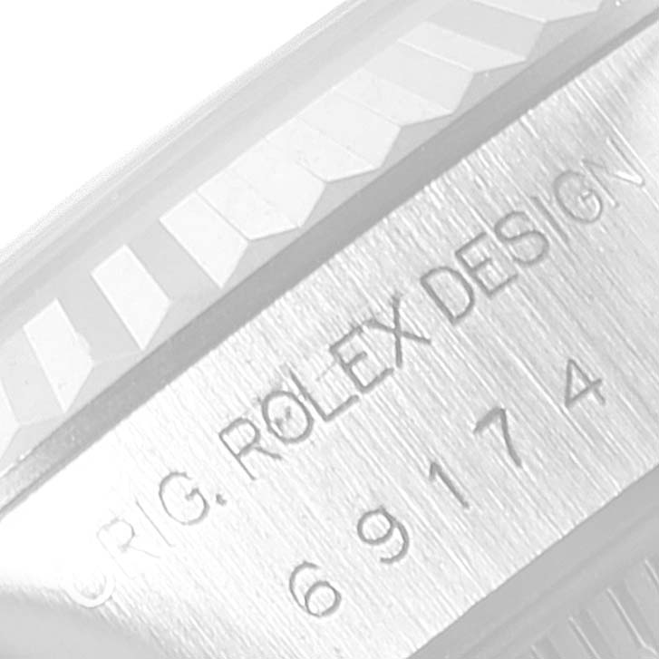 The image shows a close-up of the side engraving and fluted bezel edge of a Rolex Date 69174 Women
s Stainless Steel White Dial 69174 Women
s Stainless Steel White Dial model watch.