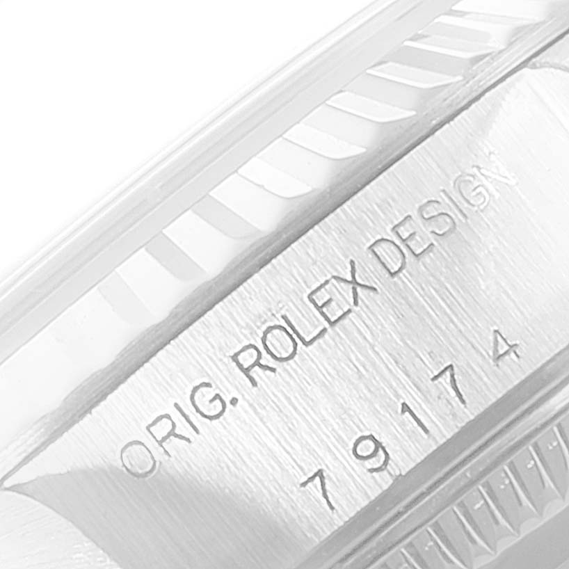 The image shows a close-up of the side of a Rolex Datejust 79174 Women's Stainless Steel Pink Dial 79174 Women's Stainless Steel Pink Dial watch, specifically its engraved serial number and "ORIG. ROLEX DESIGN" text.