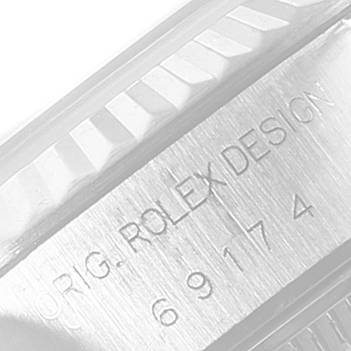 This close-up image shows the engraved model number and 
ORIG. ROLEX DESIGN
 on the side of a Rolex Datejust 69174 Women
s Stainless Steel Black Dial 69174 Women
s Stainless Steel Black Dial watch case.