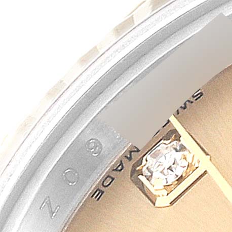 This image shows a close-up of the bezel and partial dial of a Rolex Datejust 179173 Women's Steel and Gold (two tone) Champagne Dial 179173 Women's Steel and Gold (two tone) Champagne Dial watch, featuring a diamond hour marker and "SWISS MADE" text.