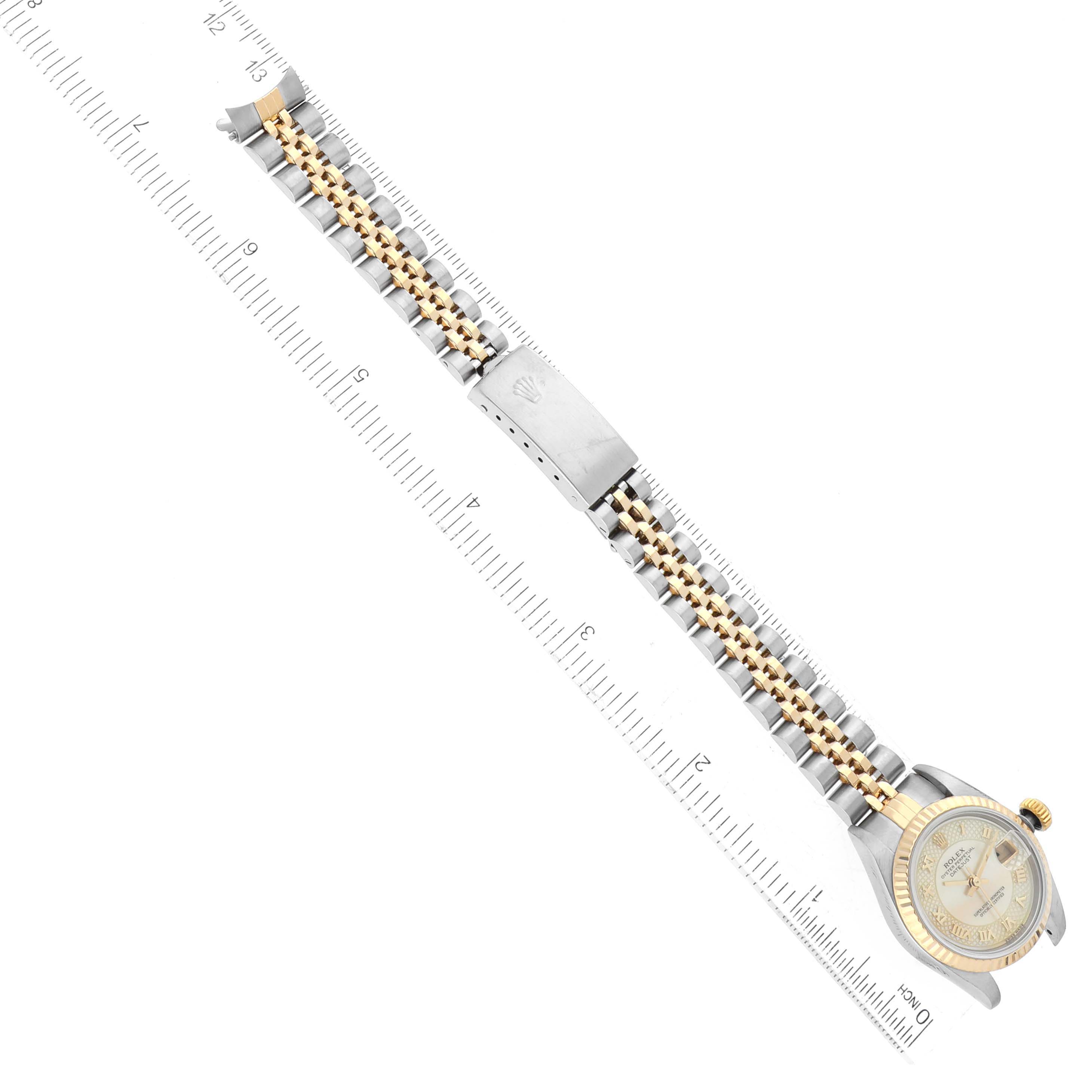 This image of a Rolex Datejust 79173 Women's Steel and Gold (two tone) Mother of Pearl Dial 79173 Women's Steel and Gold (two tone) Mother of Pearl Dial model watch shows it from a top-down angle displaying the full bracelet and some case details alongside a ruler.