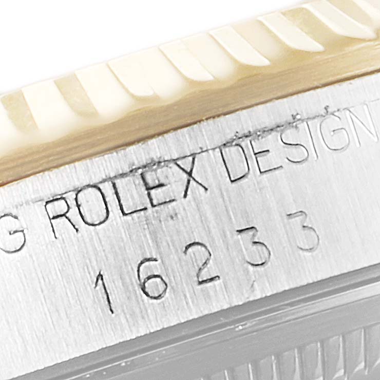 The image shows the engraved side case and part of the fluted bezel of a Rolex Datejust 16233 Men's Steel and Gold (two tone) Silver Dial 16233 Men's Steel and Gold (two tone) Silver Dial model 16233.