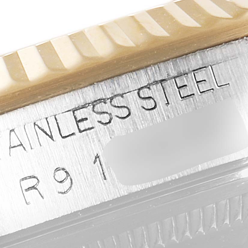 The image shows a close-up of the bezel and engraved stainless steel part of a Rolex Datejust 16233 Men's Steel and Gold (two tone) Silver Dial 16233 Men's Steel and Gold (two tone) Silver Dial watch.