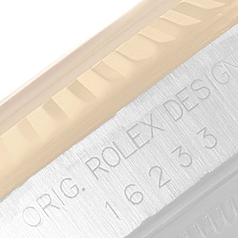 This close-up image shows part of the fluted bezel and the engraved side of the case of a Rolex Datejust 16233 Men's Steel and Gold (two tone) Silver Dial 16233 Men's Steel and Gold (two tone) Silver Dial watch.