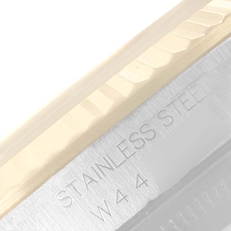 This image shows a close-up of the Rolex Datejust 16233 Men's Steel and Gold (two tone) Silver Dial 16233 Men's Steel and Gold (two tone) Silver Dial watch's bezel and part of the stainless steel casing with engravings.