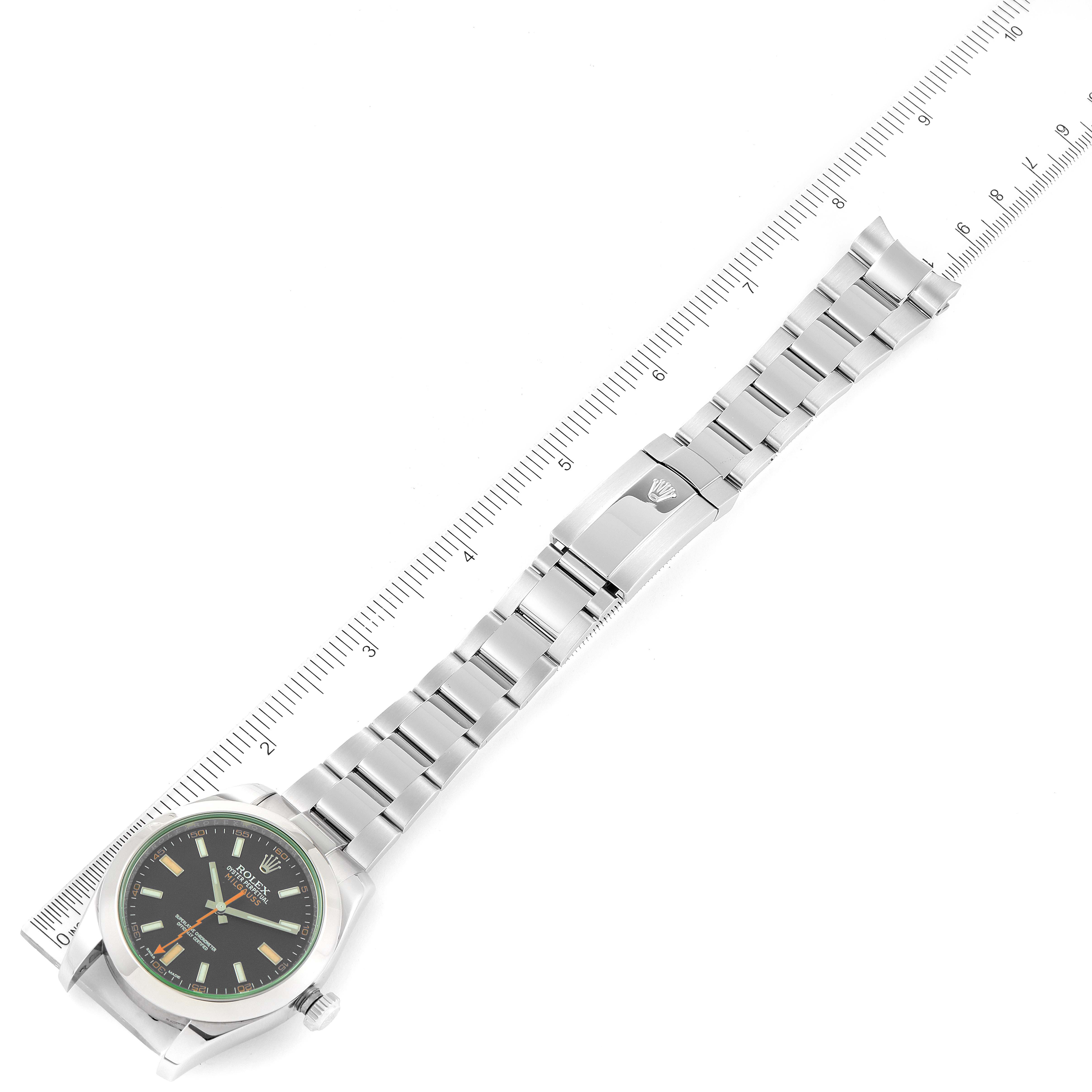 The image shows a flat-lay view of a Rolex Milgauss 116400GV Men's Stainless Steel Black Dial 116400GV Men's Stainless Steel Black Dial watch including its stainless steel bracelet and clasp, alongside a measuring scale.