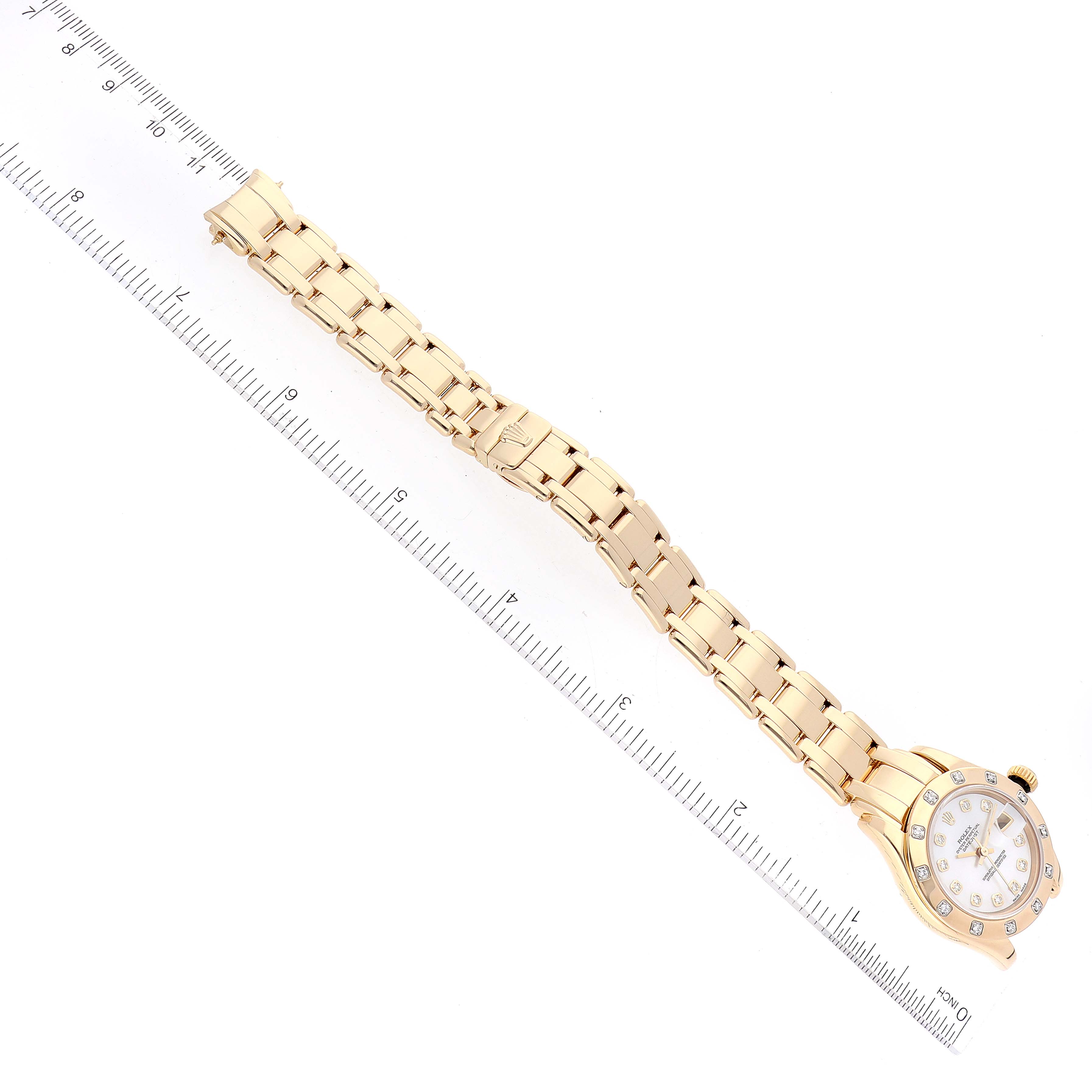 The image shows a Rolex Pearlmaster 69318 Women
s Yellow Gold Mother of Pearl Dial 69318 Women
s Yellow Gold Mother of Pearl Dial watch laid flat next to a ruler, displaying the full bracelet and face.