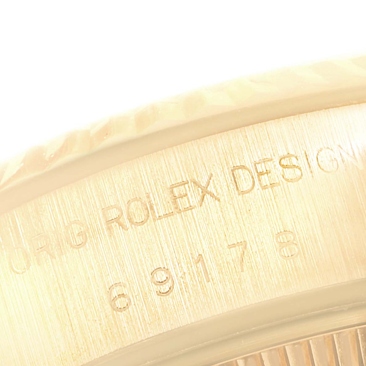 The image shows a close-up of the engraved side casing on a Rolex President 69178 Women
s Yellow Gold Champagne Dial 69178 Women
s Yellow Gold Champagne Dial model watch.